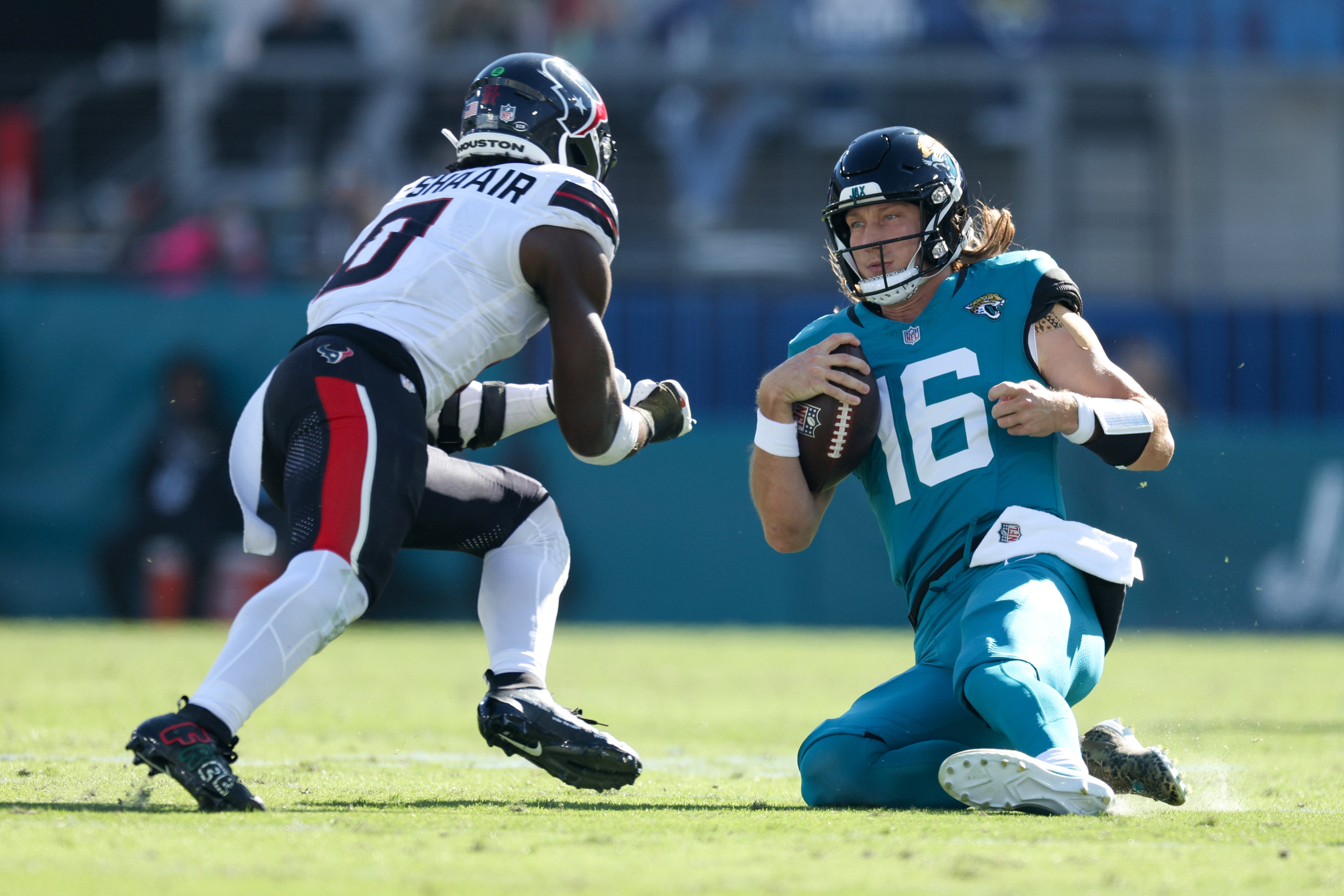 Dec 1, 2024; Jacksonville, Florida, USA; Jacksonville Jaguars quarterback Trevor Lawrence (16) slides down in front of Houston Texans linebacker Azeez Al-Shaair (0) in the second quarter in the second quarter at EverBank Stadium.