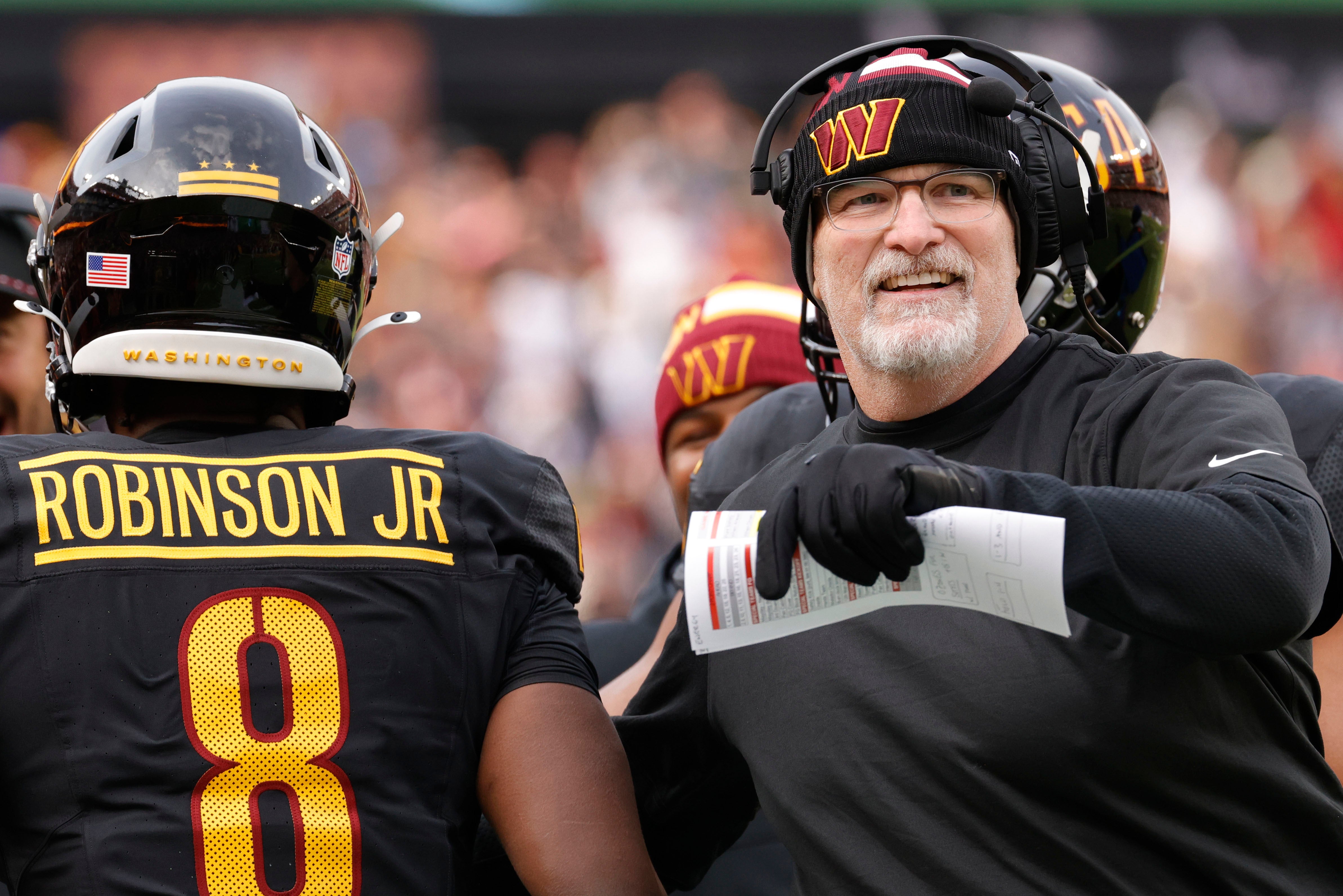 Dec 1, 2024; Landover, Maryland, USA; Washington Commanders head coach Dan Quinn (right) celebrates with Commanders running back Brian Robinson Jr. (8) after scoring a touchdown against the Tennessee Titans during the first half at Northwest Stadium.