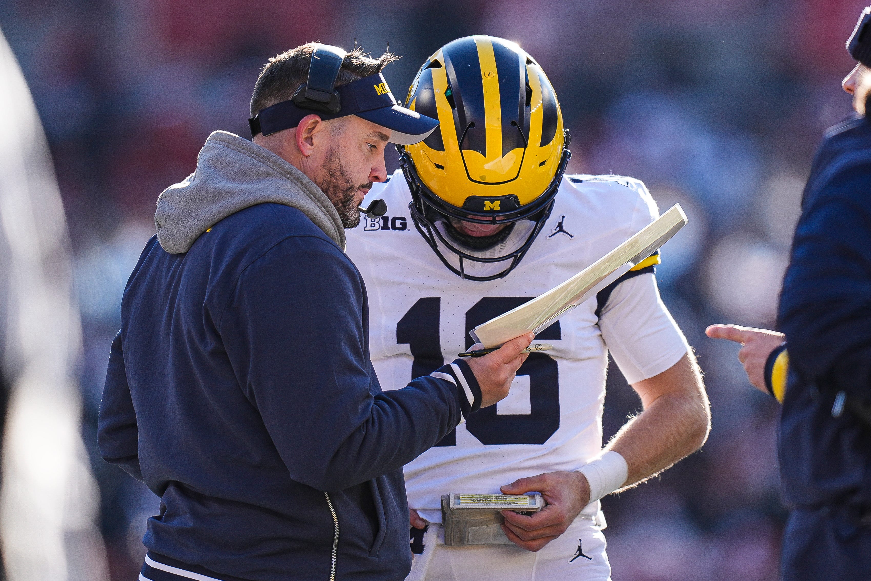 Michigan offensive coordinator Kirk Campbell talks to quarterback Davis Warren (16) at a timeout against Ohio State during the second half at Ohio Stadium in Columbus, Ohio on Saturday, Nov. 30, 2024.