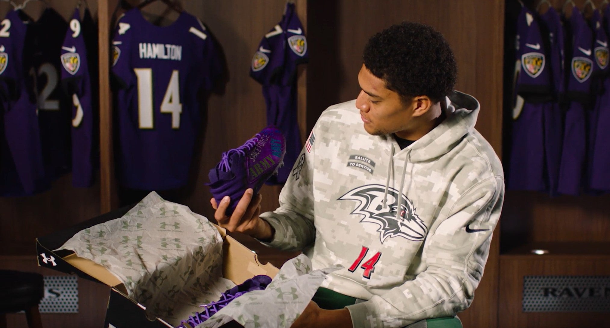 Baltimore Ravens safety Kyle Hamilton checks out his new cleats, honoring Our Military Kids with its design.