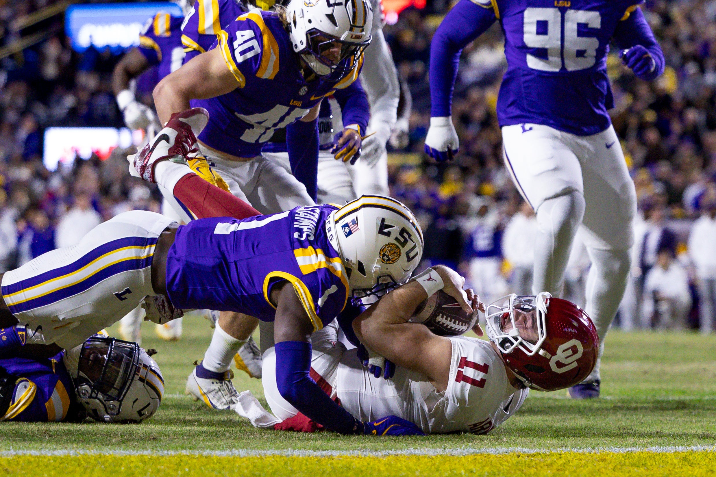 Nov 30, 2024; Baton Rouge, Louisiana, USA; Oklahoma Sooners quarterback Jackson Arnold (11) rushes against LSU Tigers safety Jardin Gilbert (2) and cornerback Ashton Stamps (1) during the second quarter at Tiger Stadium.