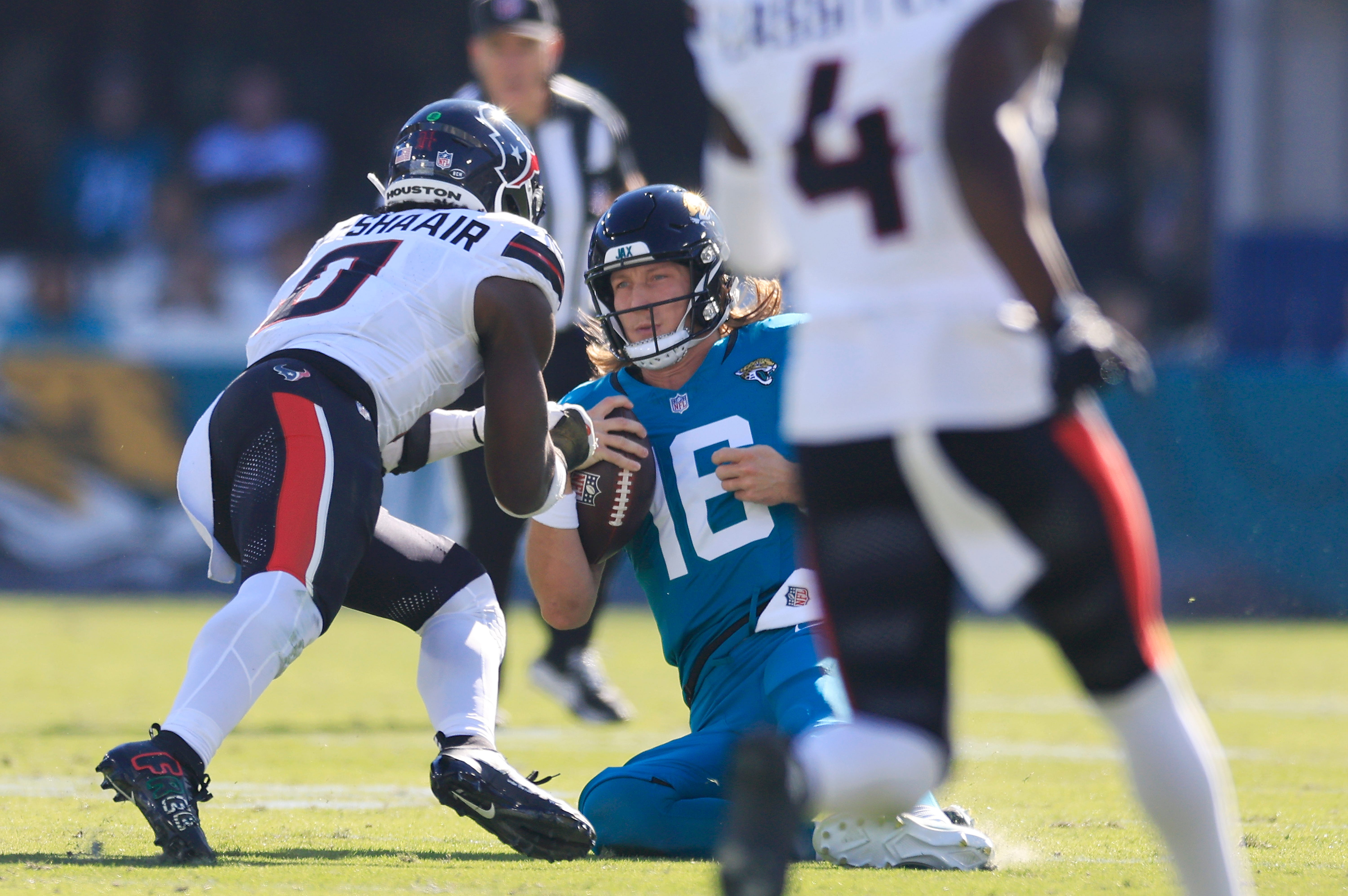 Jacksonville Jaguars quarterback Trevor Lawrence (16) slides for a down as Houston Texans linebacker Azeez Al-Shaair (0) makes a late hit during the second quarter of an NFL football matchup Sunday, Dec. 1, 2024 at EverBank Stadium in Jacksonville, Fla. [Corey Perrine/Florida Times-Union]