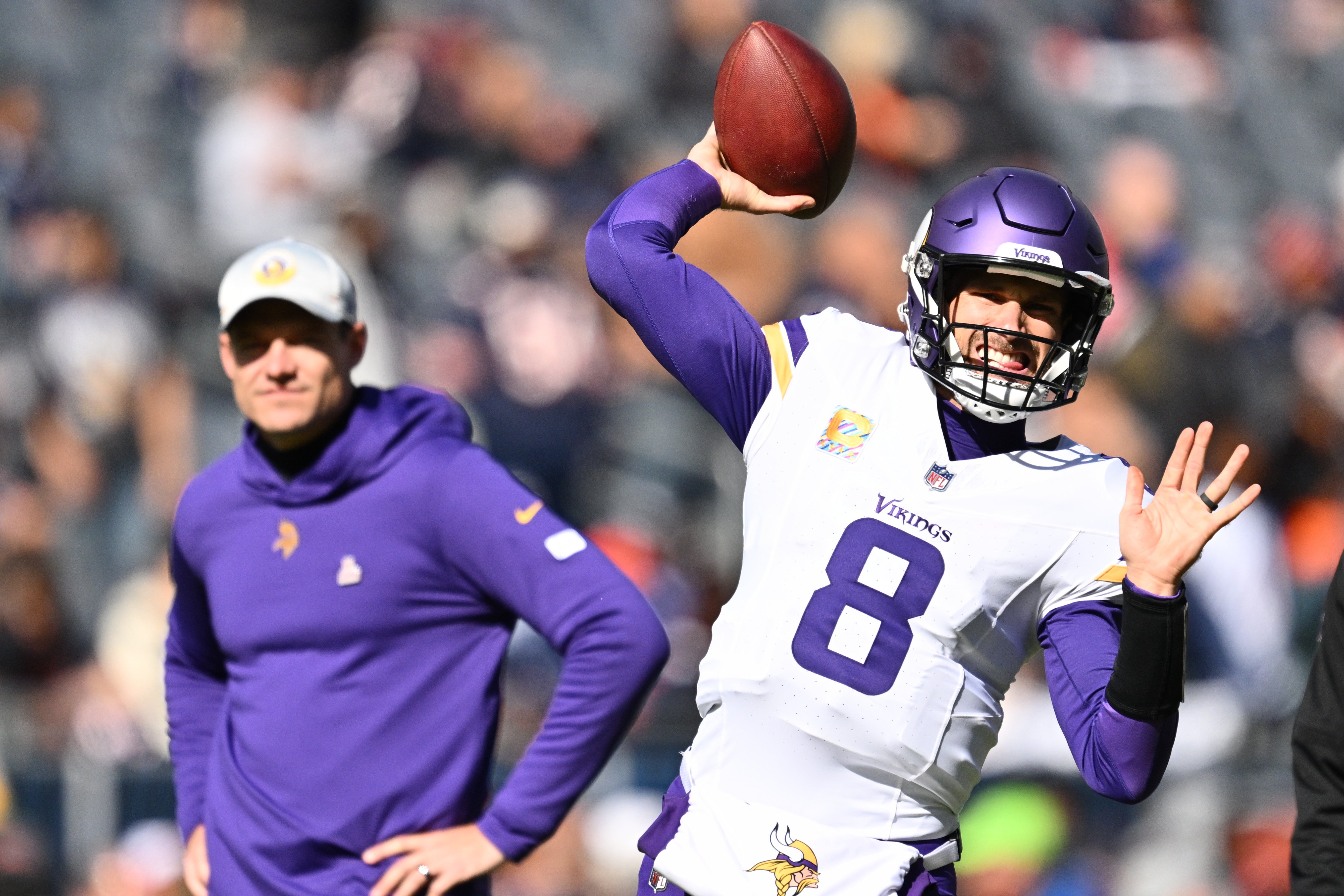 Oct 15, 2023; Chicago, Illinois, USA; Minnesota Vikings quarterback Kirk Cousins (8) warms up before a game against the Chicago Bears at Soldier Field with head coach Kevin O'Connell watching in the background.
