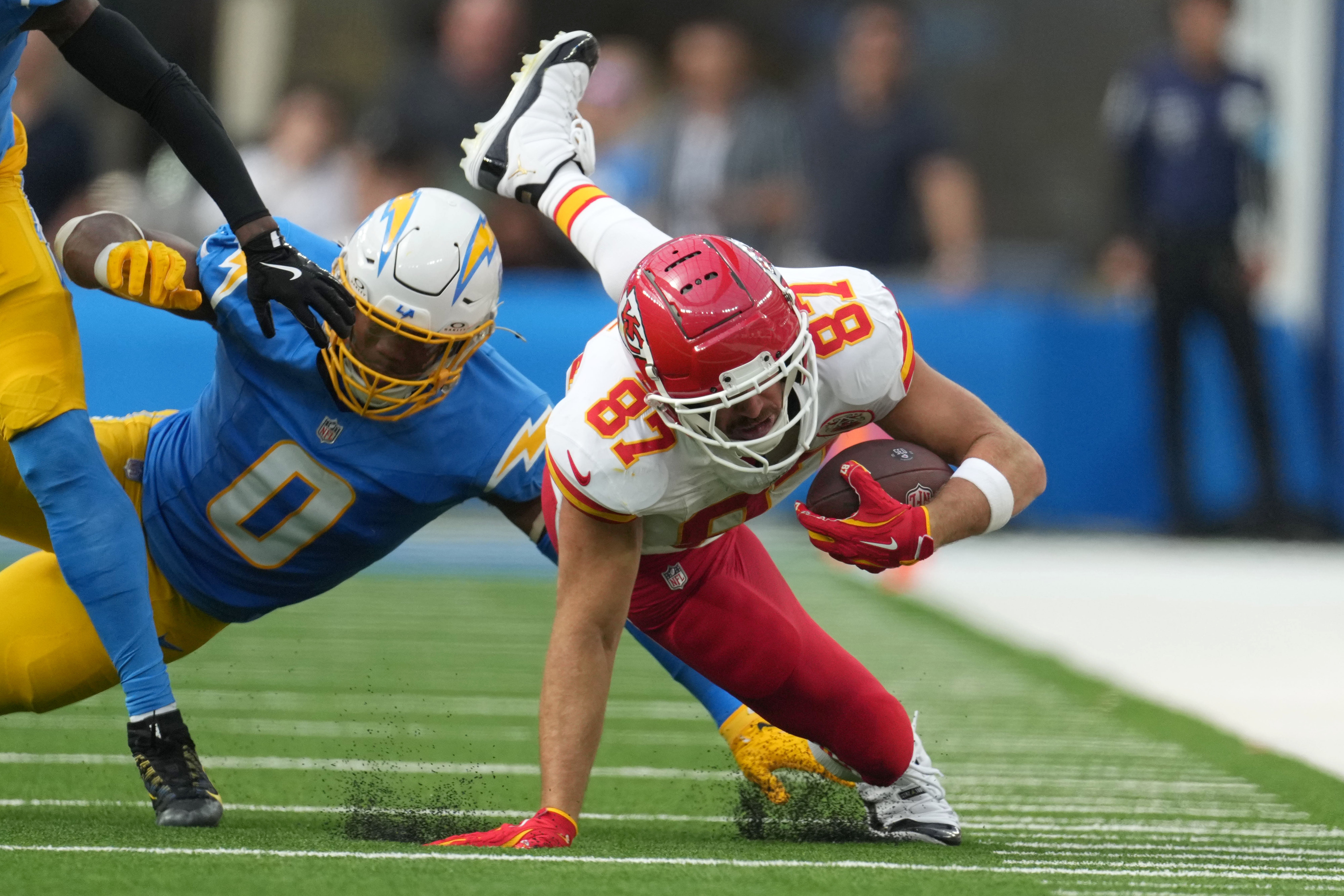 Sep 29, 2024; Inglewood, California, USA; Kansas City Chiefs tight end Travis Kelce (87) runs against Los Angeles Chargers linebacker Daiyan Henley (0) in the second half at SoFi Stadium.