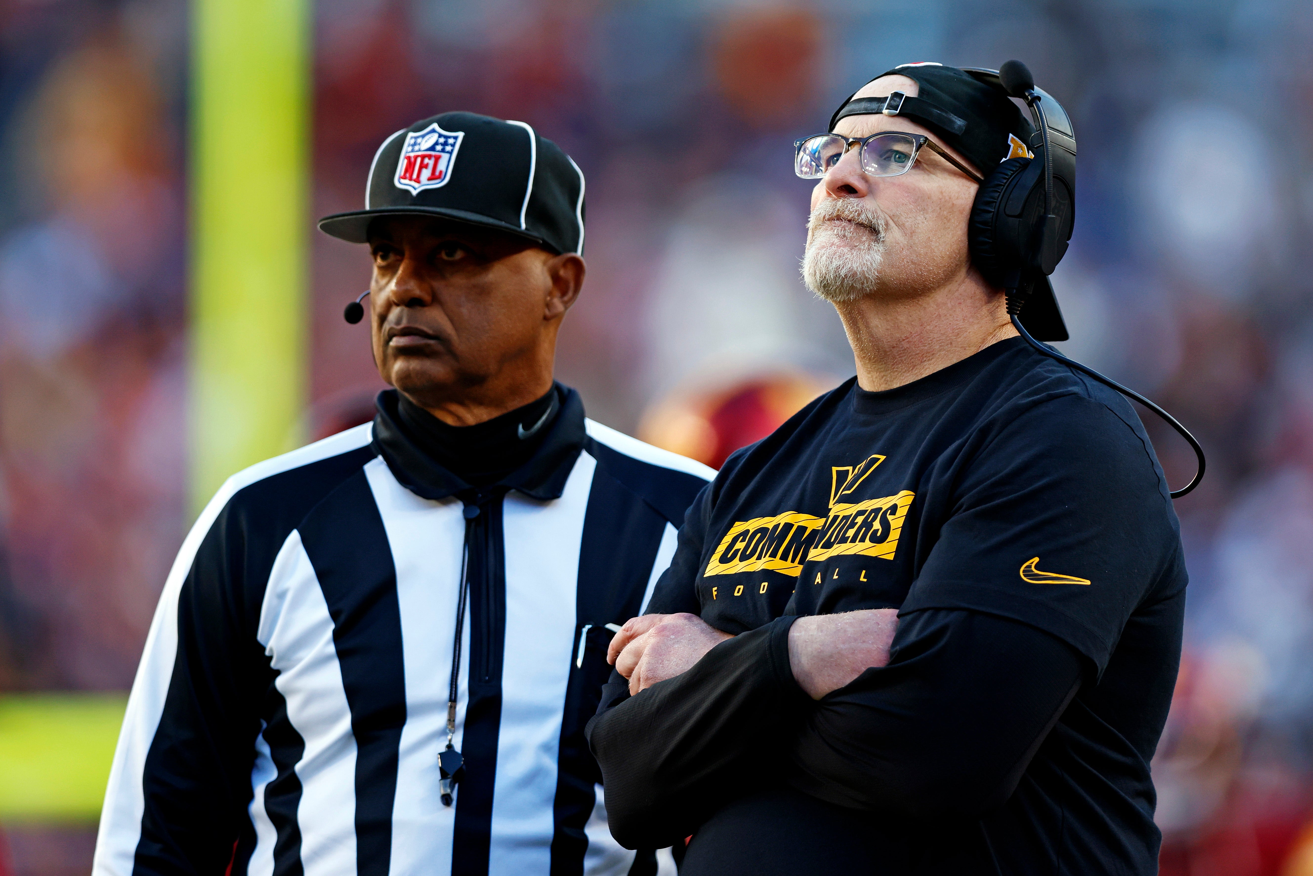 Nov 24, 2024; Landover, Maryland, USA; Washington Commanders head coach Dan Quinn watches a replay on the video board during the third quarter of the game against the Dallas Cowboys at Northwest Stadium.