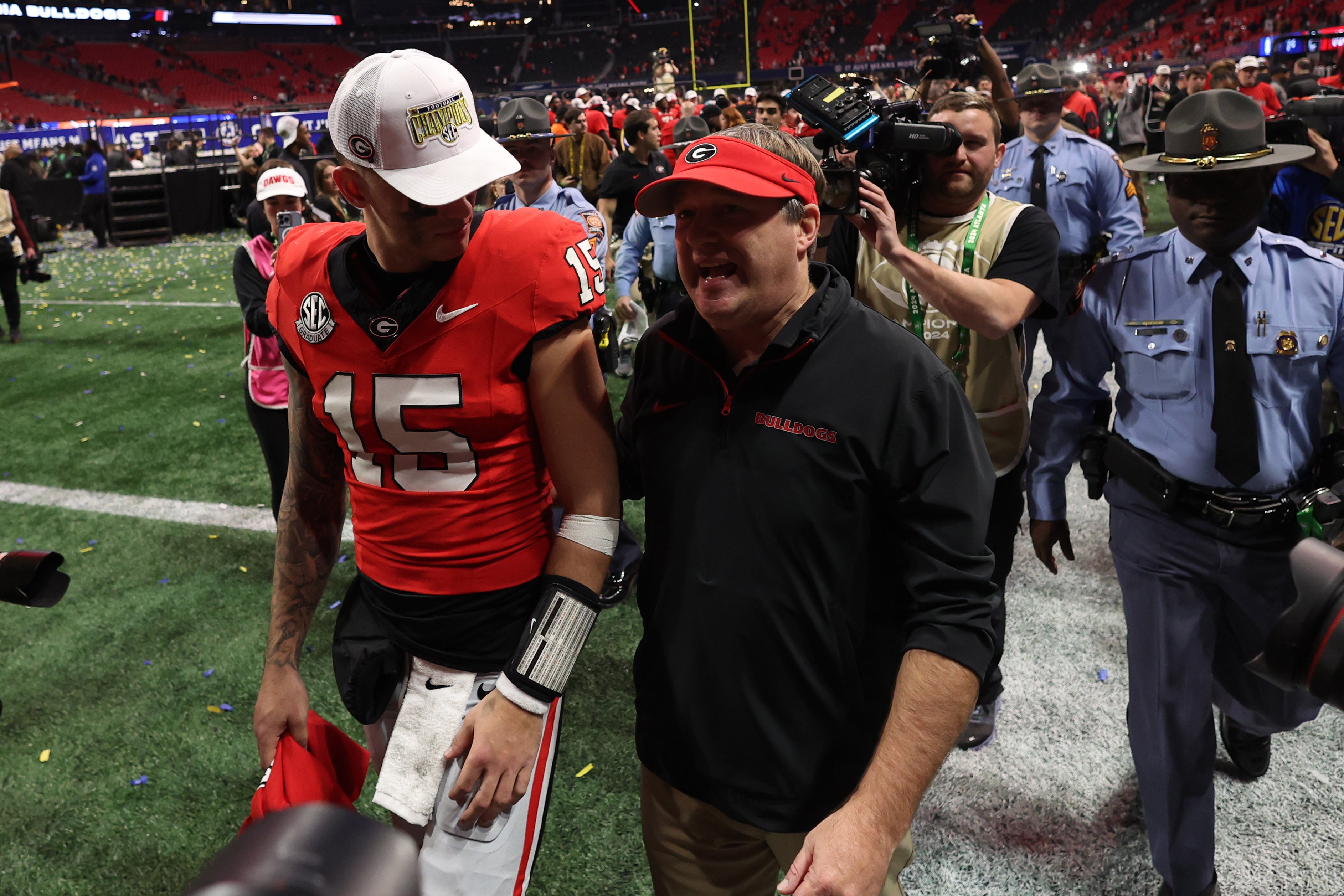Georgia Bulldogs quarterback Carson Beck (15) and head coach Kirby Smart react after defeating the Texas Longhorns in overtime in the 2024 SEC Championship game at Mercedes-Benz Stadium.