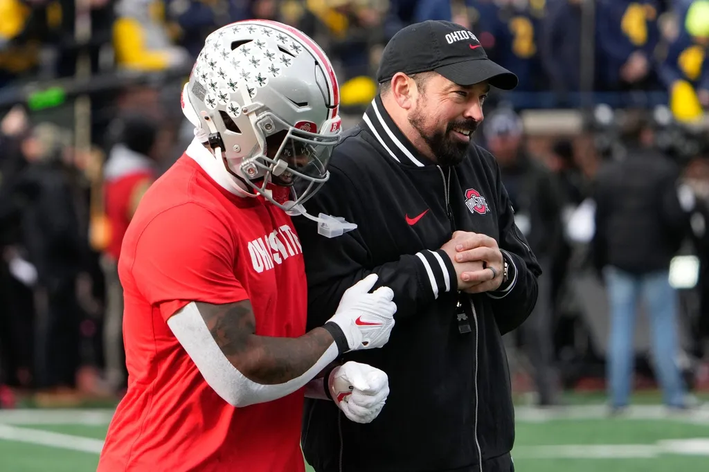 Ohio State Buckeyes head coach Ryan Day ljokes around with running back Chip Trayanum during warm-ups prior to the NCAA football game against the Michigan Wolverines at Michigan Stadium