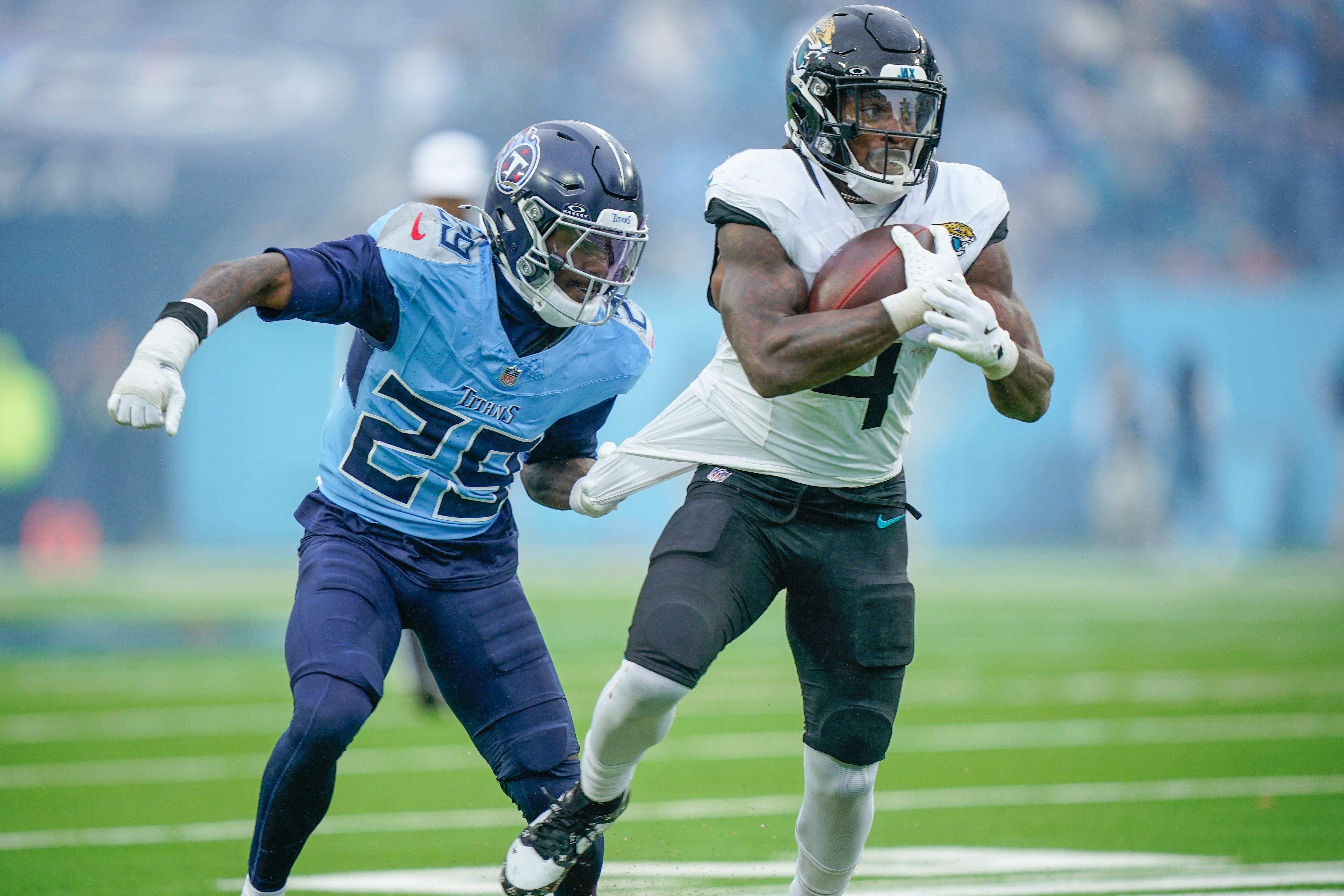 Tennessee Titans cornerback Jarvis Brownlee Jr. (29) grabs Jacksonville Jaguars running back Tank Bigsby (4) during the fourth quarter at Nissan Stadium in Nashville, Tenn., Sunday, Dec. 8, 2024 Denny Simmons / The Tennessean-USA TODAY NETWORK via Imagn Images