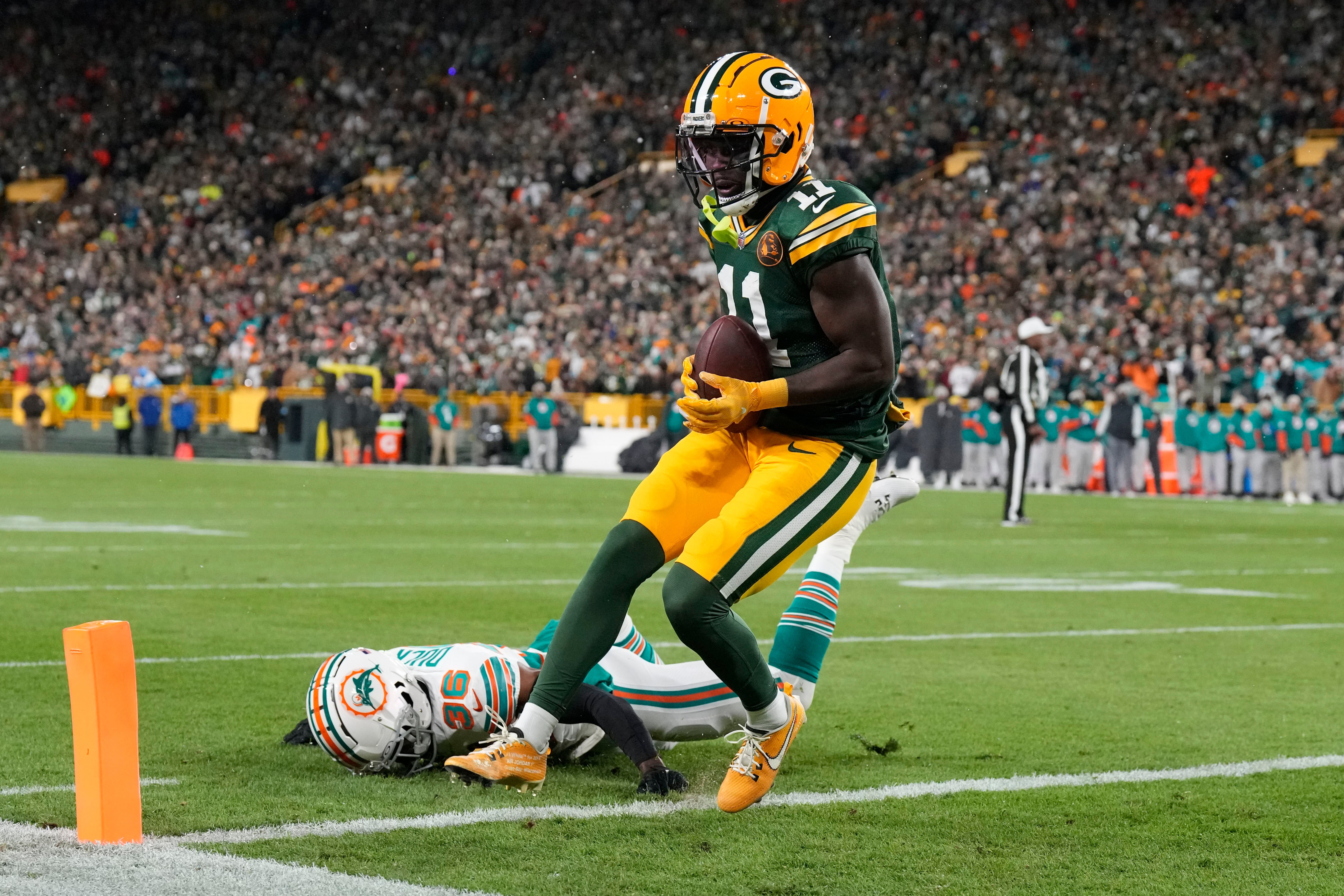 Green Bay Packers wide receiver Jayden Reed (11) scores a touchdown in front of Miami Dolphins cornerback Storm Duck (36) during the first quarter at Lambeau Field.