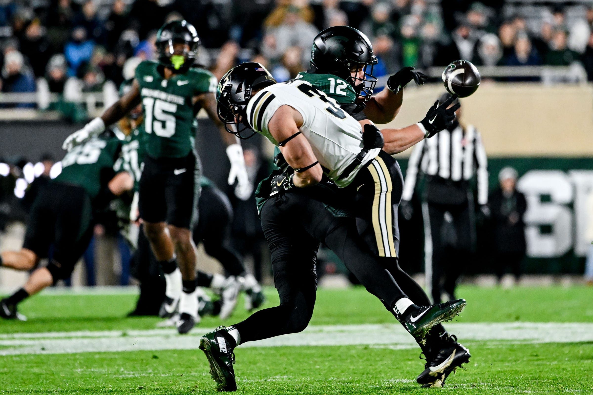 Michigan State's Jack Velling (12) is injured on a hit by Purdue's Dillon Thieneman during the first quarter on Friday, Nov. 22, 2024, at Spartan Stadium in East Lansing.