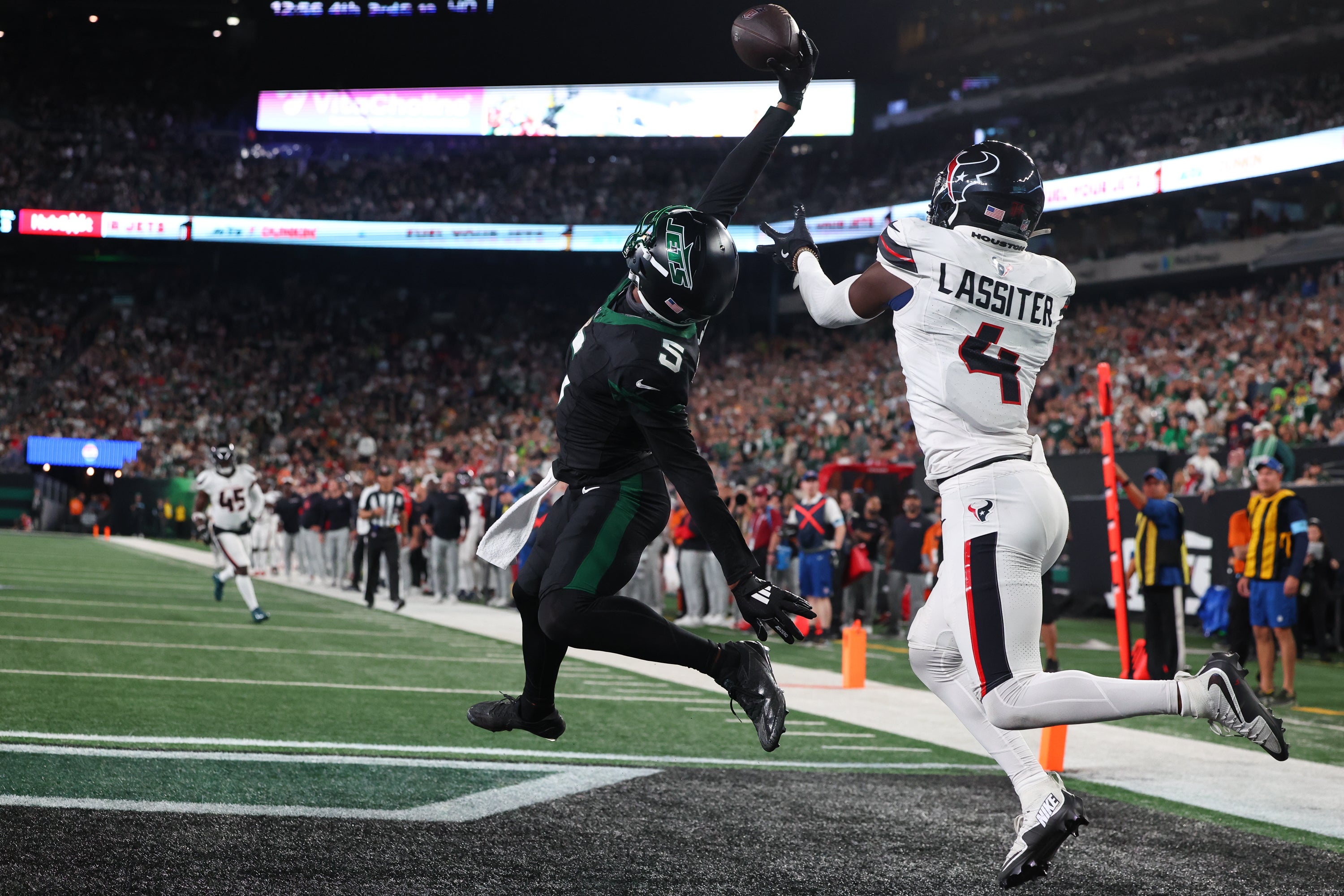 New York Jets wide receiver Garrett Wilson (5) catches a touchdown pass while being defended by Houston Texans cornerback Kamari Lassiter (4) during the second half at MetLife Stadium.