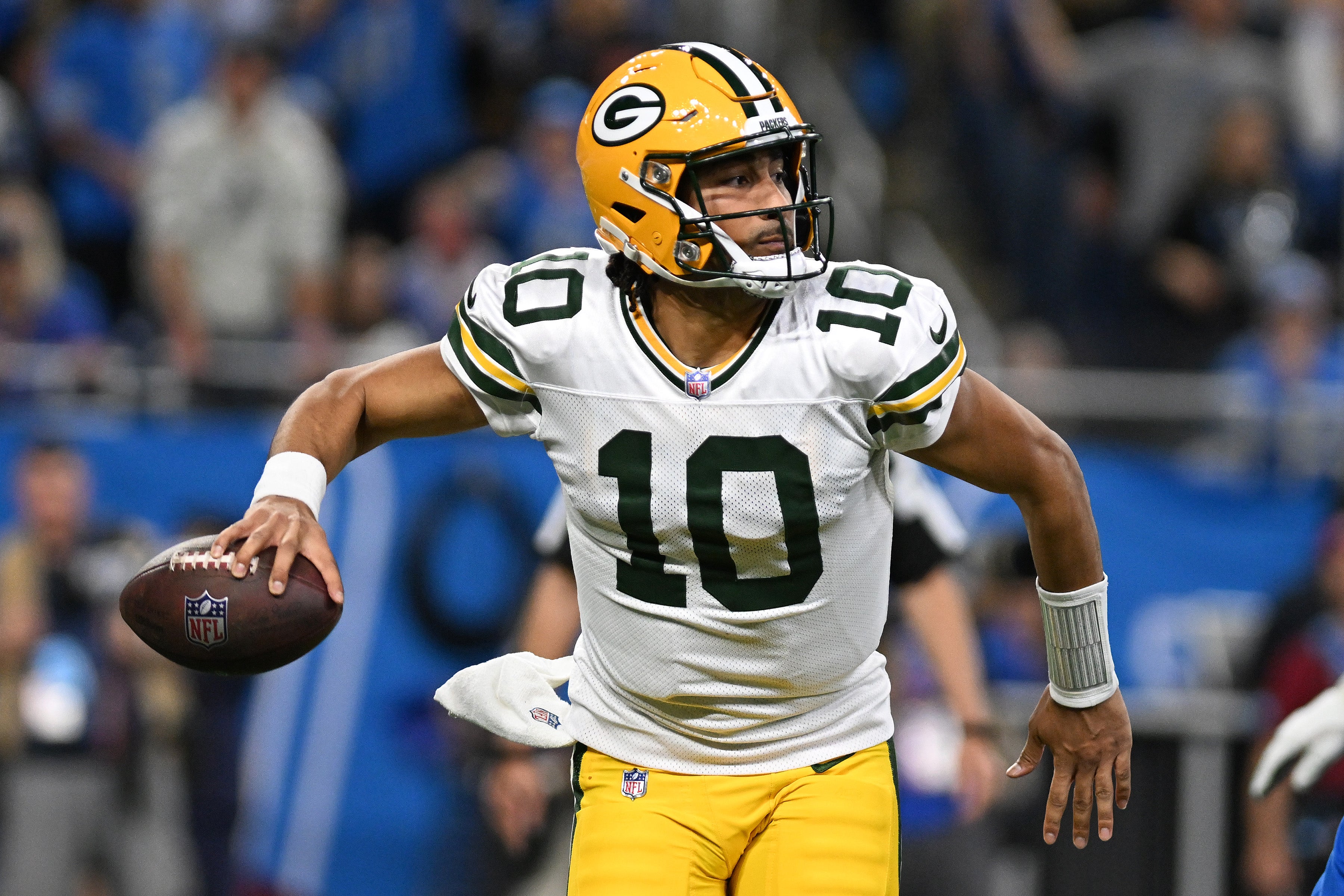 Green Bay Packers quarterback Jordan Love (10) looks for an open receiver as he scrambles out of the pocket against the Detroit Lions in the third quarter at Ford Field.