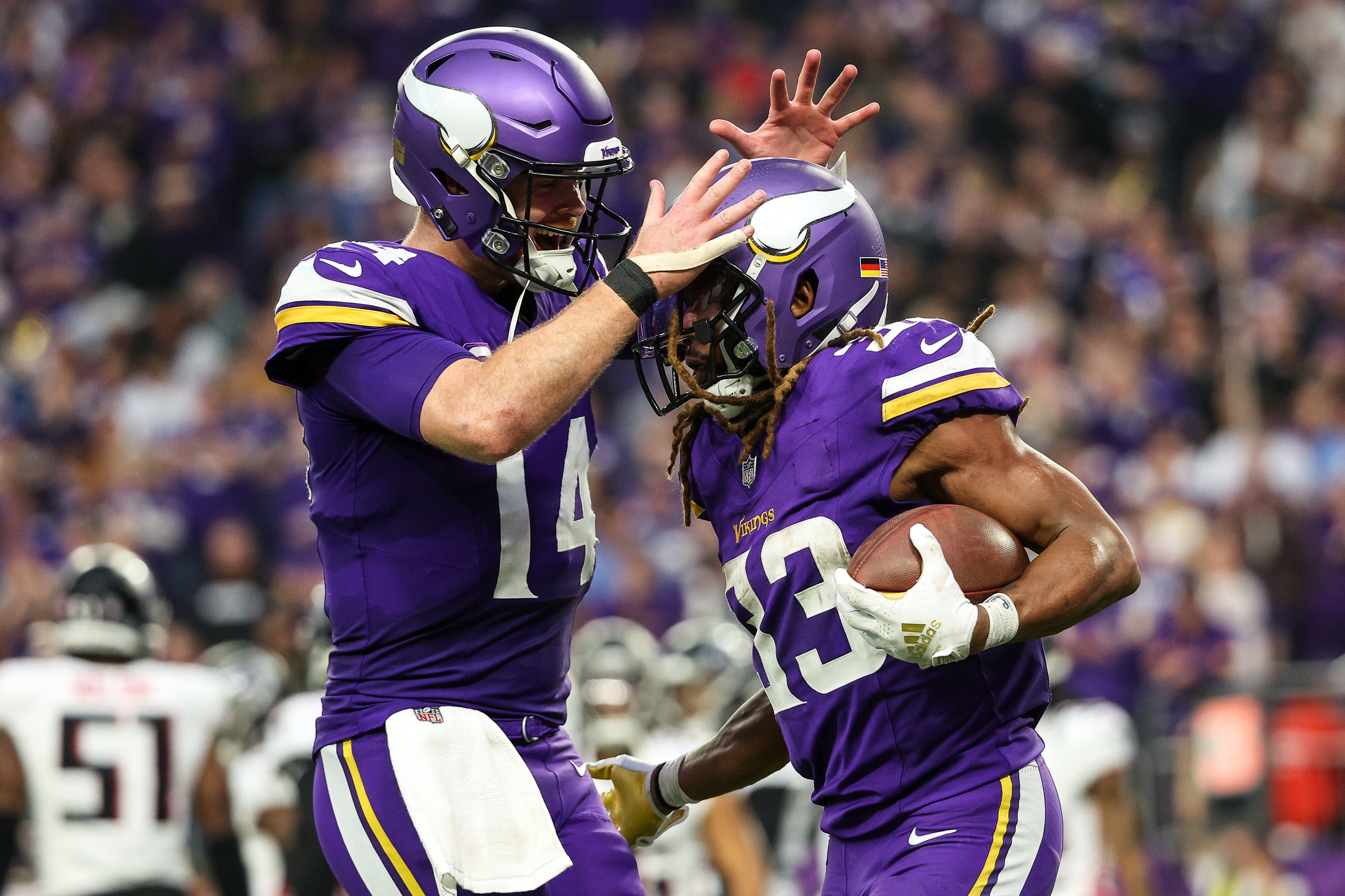 Dec 8, 2024; Minneapolis, Minnesota, USA; Minnesota Vikings running back Aaron Jones (33) celebrates his running touchdown with quarterback Sam Darnold (14) during the fourth quarter against the Atlanta Falcons at U.S. Bank Stadium.