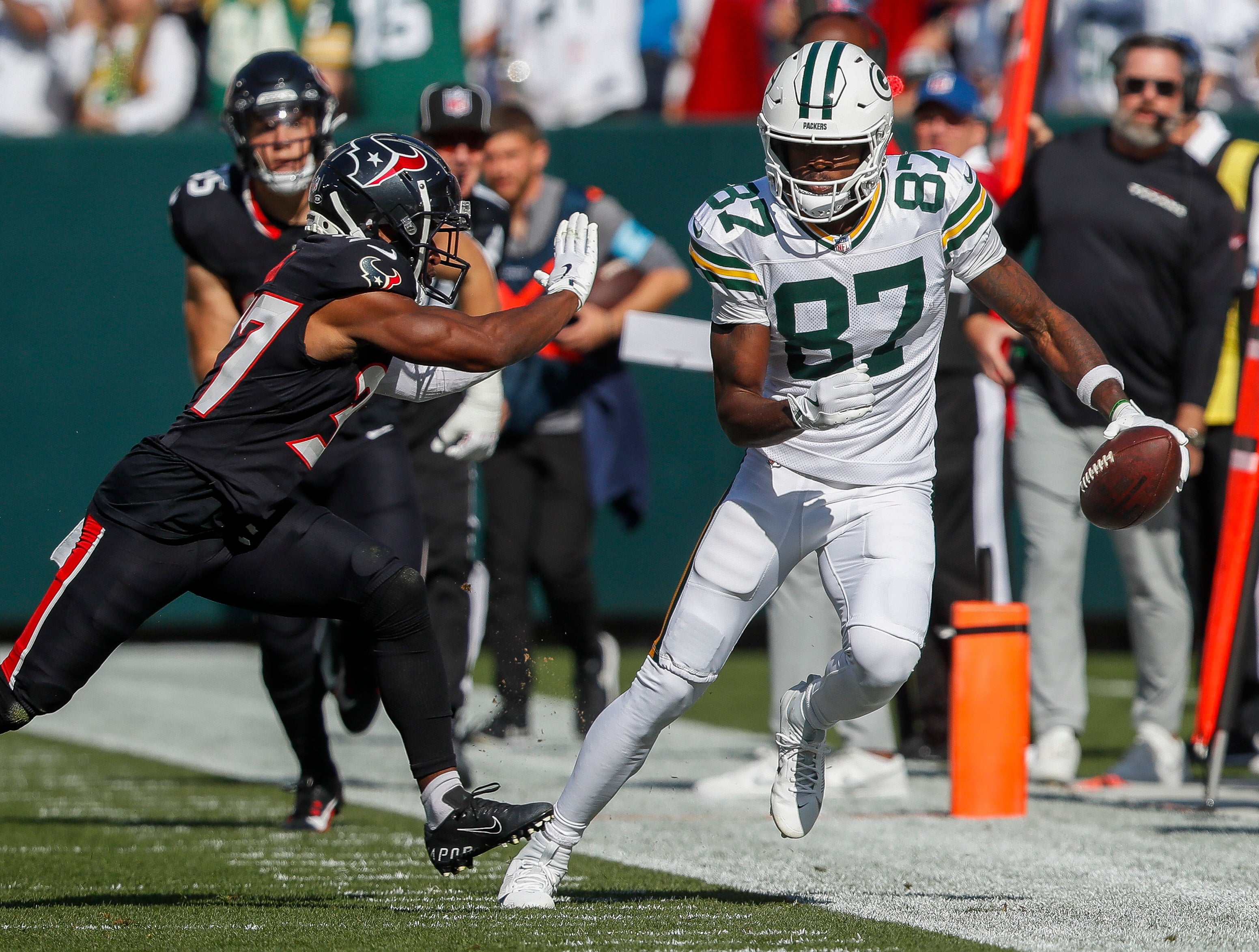 Green Bay Packers wide receiver Romeo Doubs (87) is forced out of bounds by Houston Texans cornerback D'Angelo Ross (37) after making a reception at Lambeau Field.