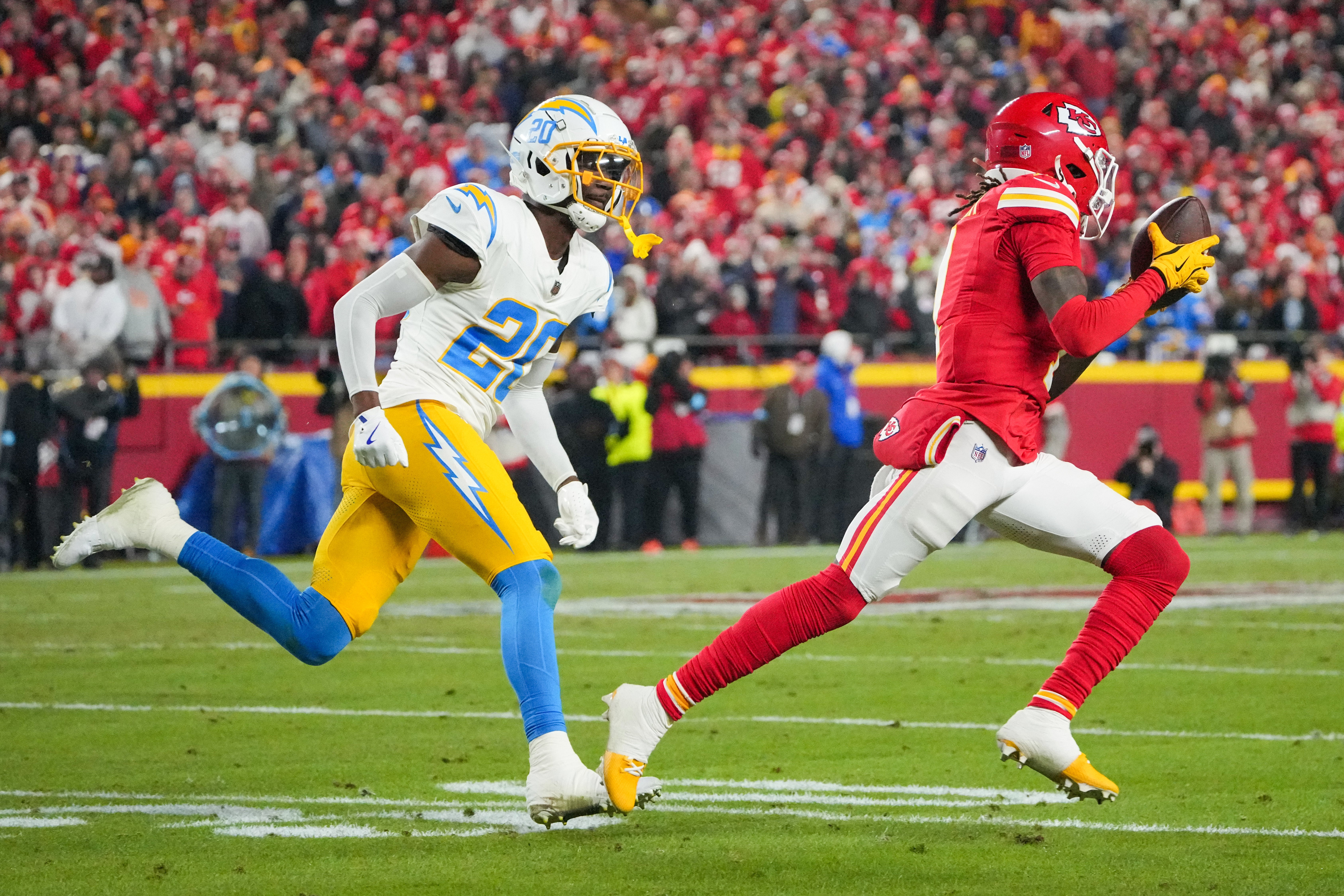 Chiefs wide receiver Xavier Worthy (1) runs the ball as Chargers cornerback Cam Hart (20) defends.