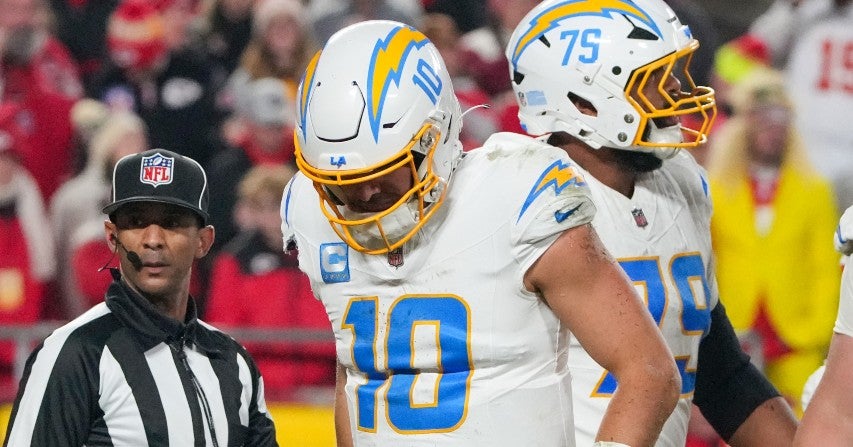 Chargers quarterback Justin Herbert (10) limps after being sacked by Chiefs defensive end Charles Omenihu (90) (not pictured) during the first half at GEHA Field at Arrowhead Stadium.