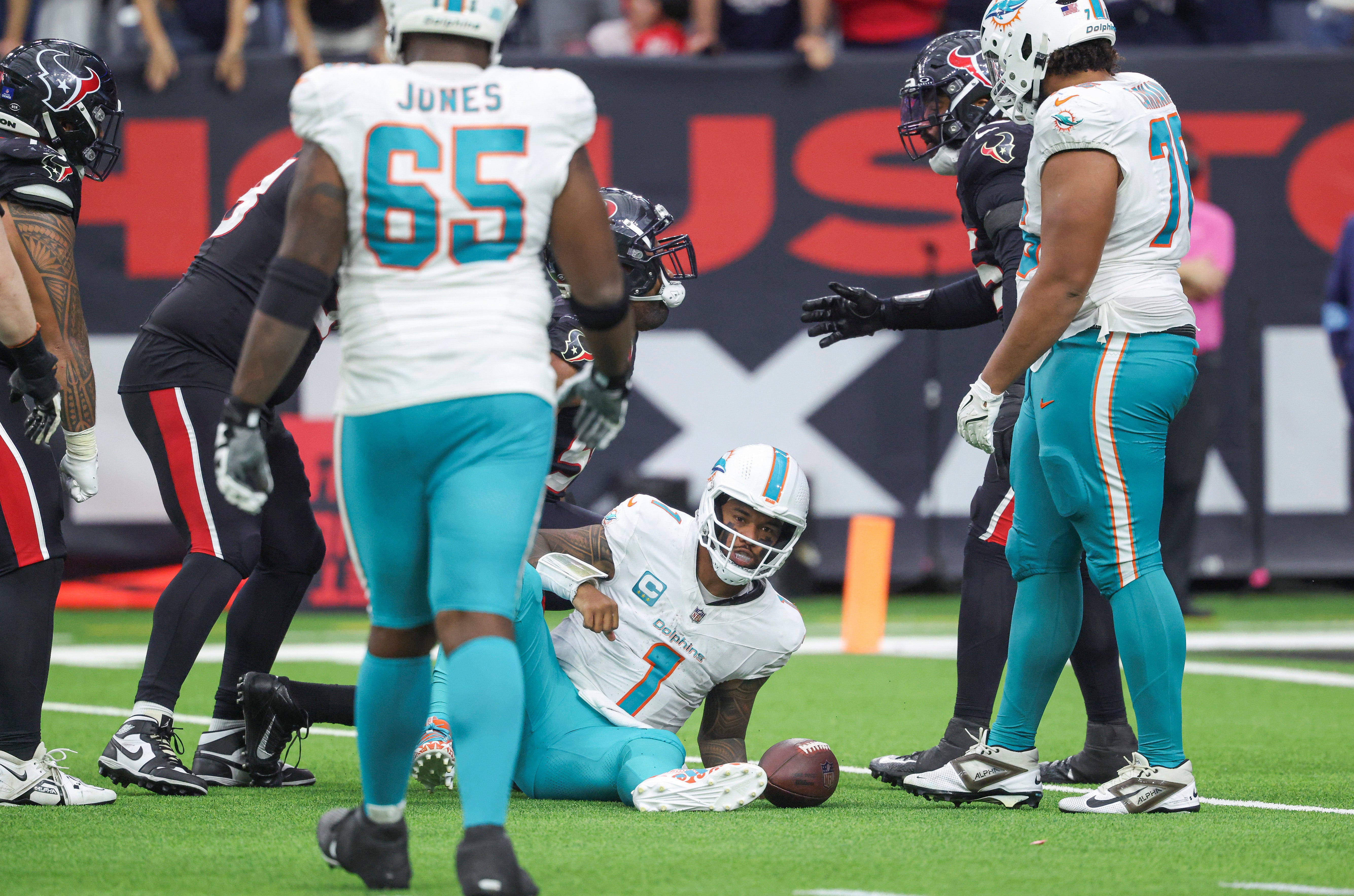 Dec 15, 2024; Houston, Texas, USA; Miami Dolphins quarterback Tua Tagovailoa (1) reacts after being sacked during the fourth quarter against the Houston Texans at NRG Stadium.