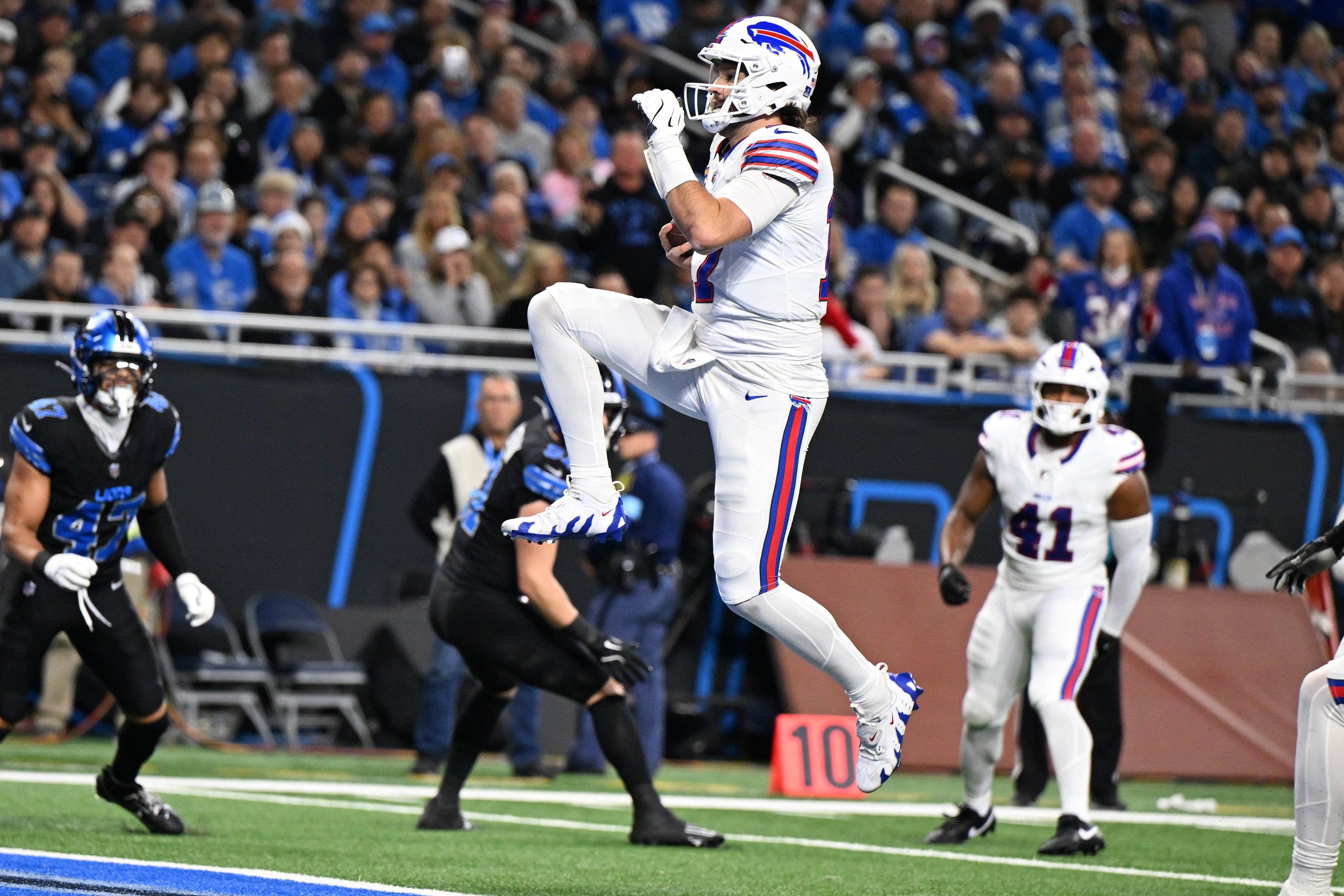 Dec 15, 2024; Detroit, Michigan, USA; Buffalo Bills quarterback Josh Allen (17) leaps across the goal line for his second touchdown of the game against the Detroit Lions in the first quarter at Ford Field.