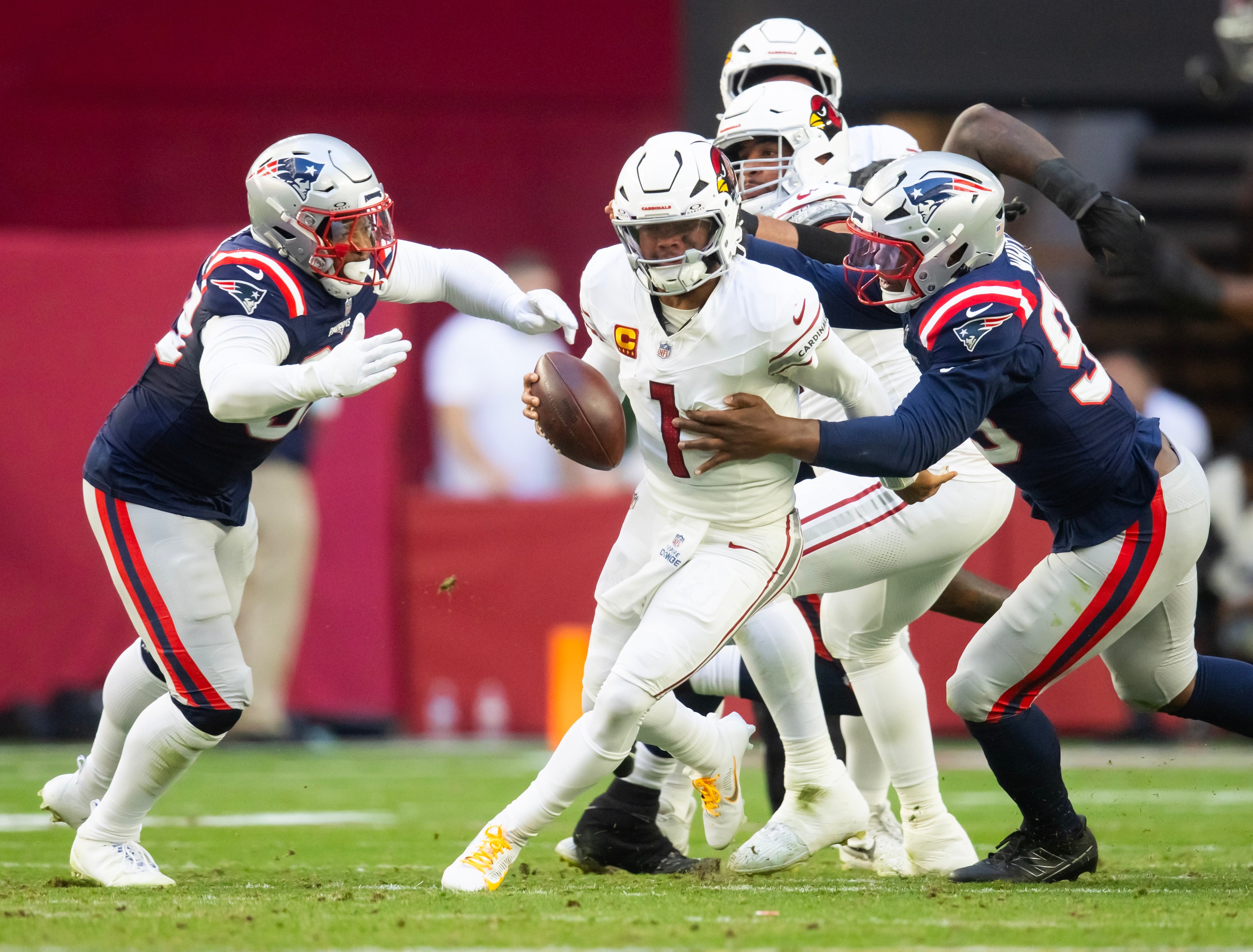 Dec 15, 2024; Glendale, Arizona, USA; Arizona Cardinals quarterback Kyler Murray (1) is sacked by New England Patriots defensive end Keion White (99) and linebacker Anfernee Jennings (33) in the first half at State Farm Stadium.