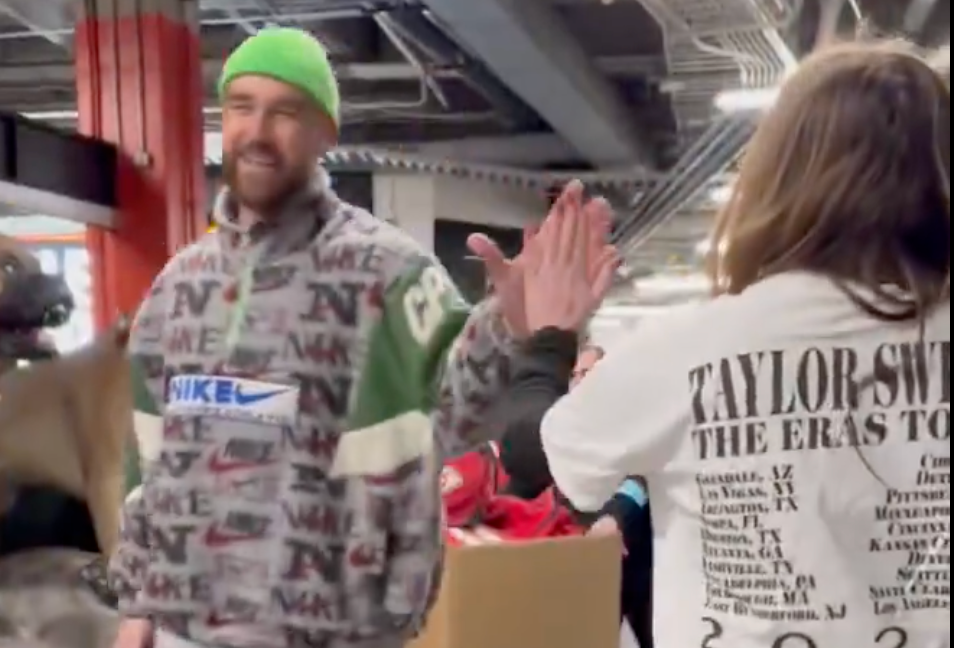 Travis Kelce meets a fan in Taylor Swift's Eras Tour merch after Chiefs-Browns game.