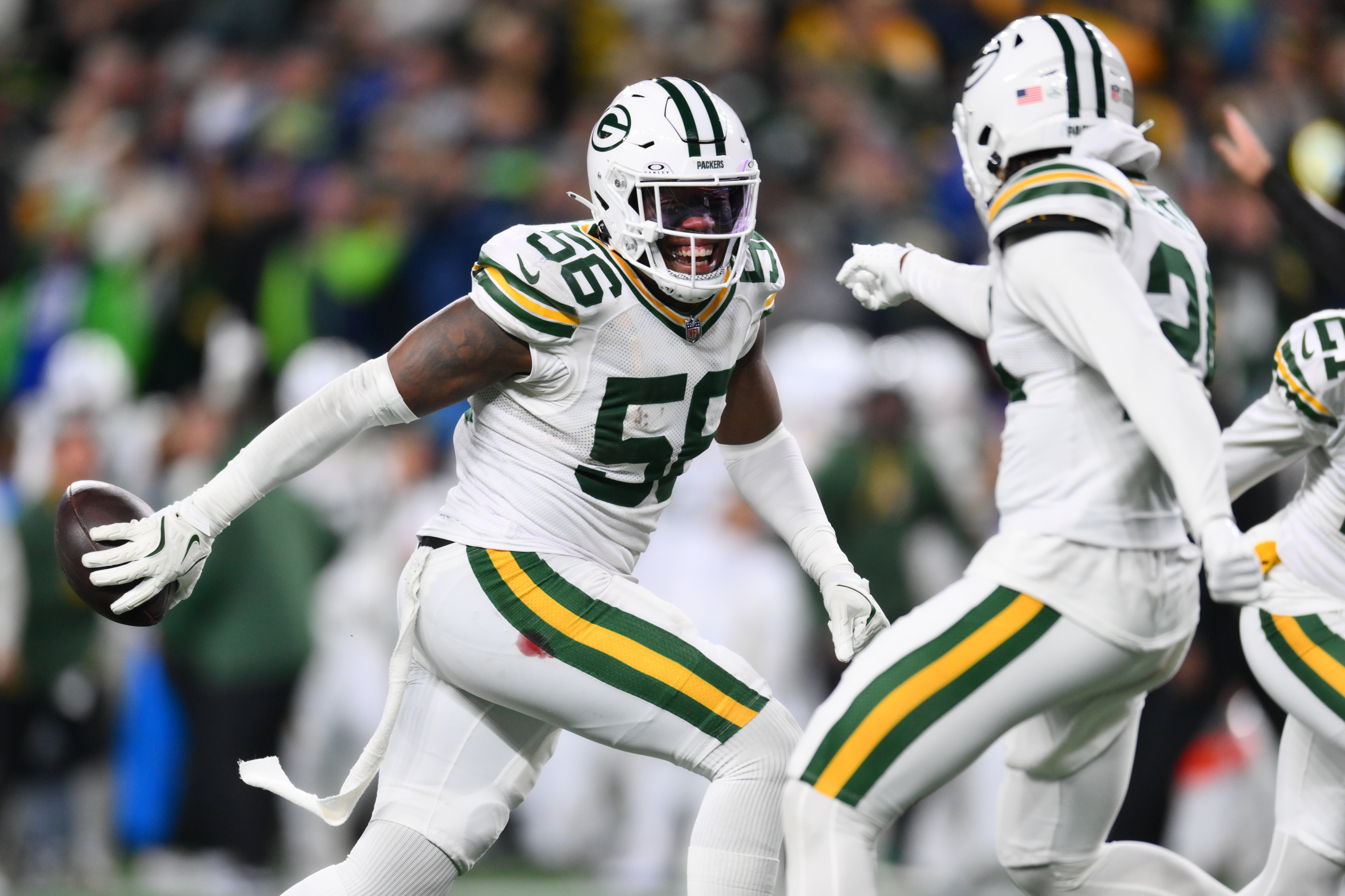 Green Bay Packers linebacker Edgerrin Cooper (56) celebrates with cornerback Carrington Valentine (24) after Cooper intercepted the ball against the Seattle Seahawks during the second half at Lumen Field.