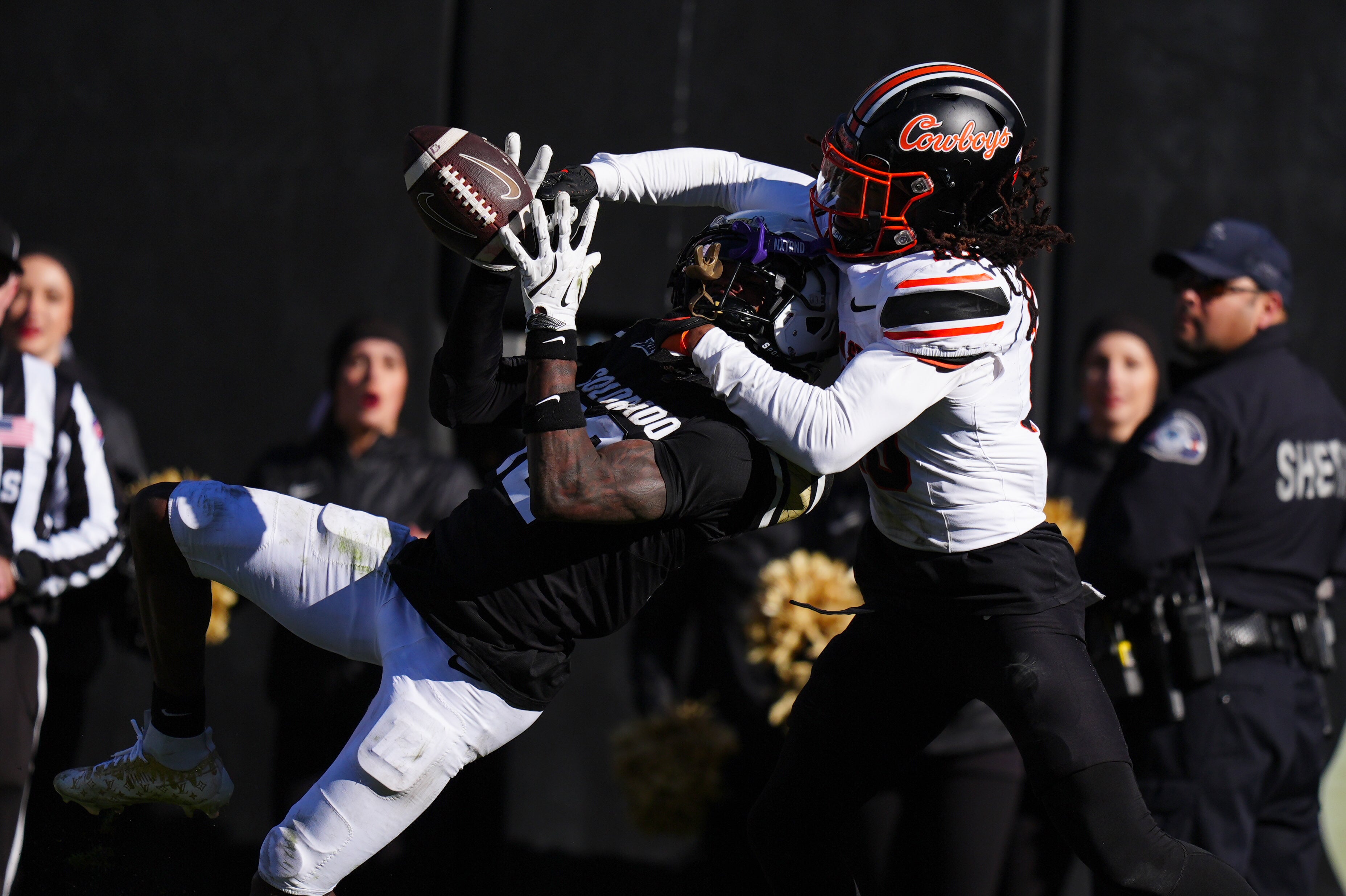 Nov 29, 2024; Boulder, Colorado, USA; Colorado Buffaloes wide receiver Travis Hunter (12) pulls in at touchdown reception as Oklahoma State Cowboys cornerback Kale Smith (10) in the fourth quarter at Folsom Field.