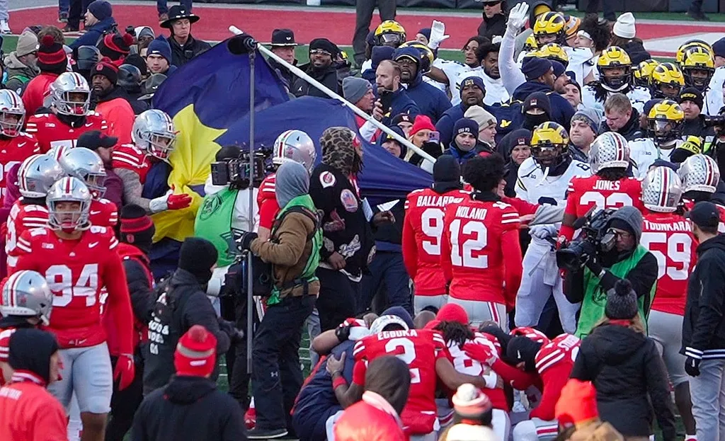 Ohio State football defensive end Jack Sawyer (33) grabs the flag that Michigan players tried to plant on the Block O in the Ohio Stadium field after the NCAA football game against the Michigan Wolverines.