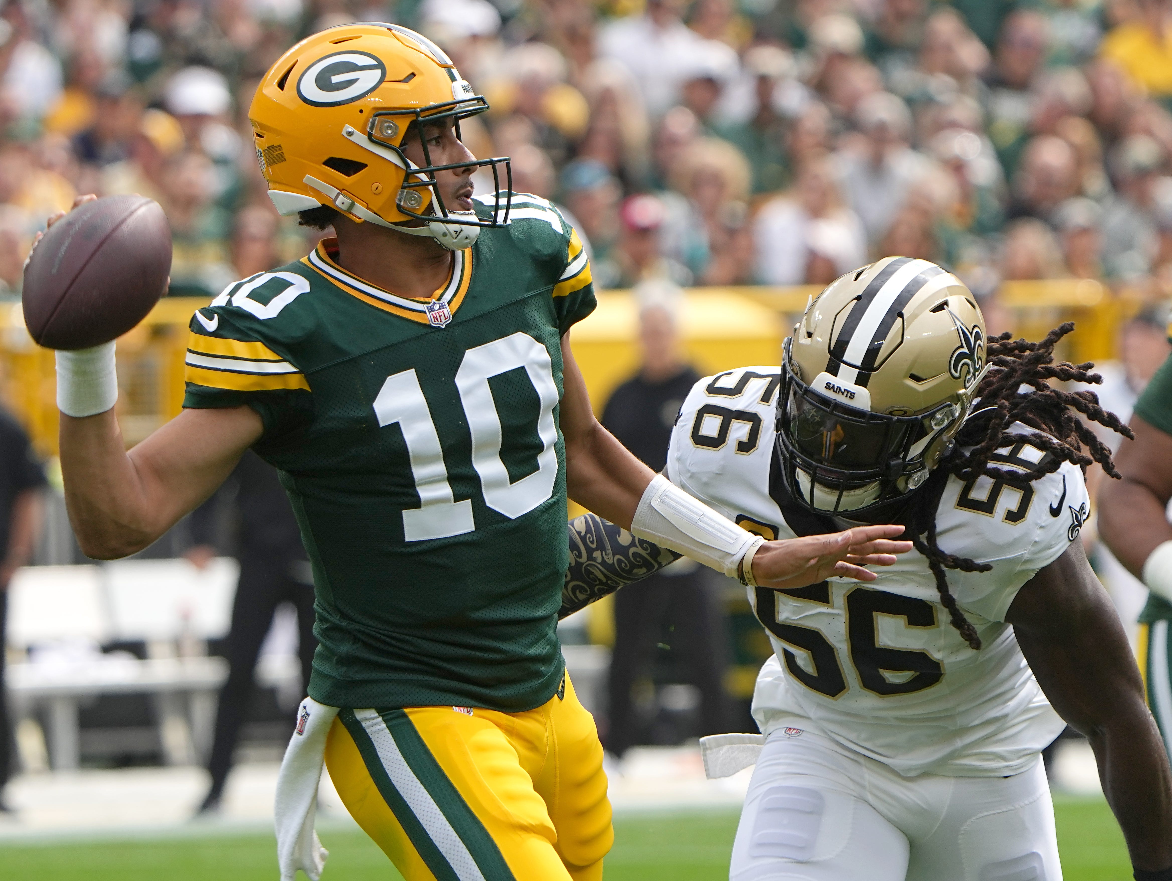 Green Bay Packers quarterback Jordan Love (10) is pressured by New Orleans Saints linebacker Demario Davis (56) during the first quarter of their game Sunday, September 24, 2023 at Lambeau Field in Green Bay, Wis.