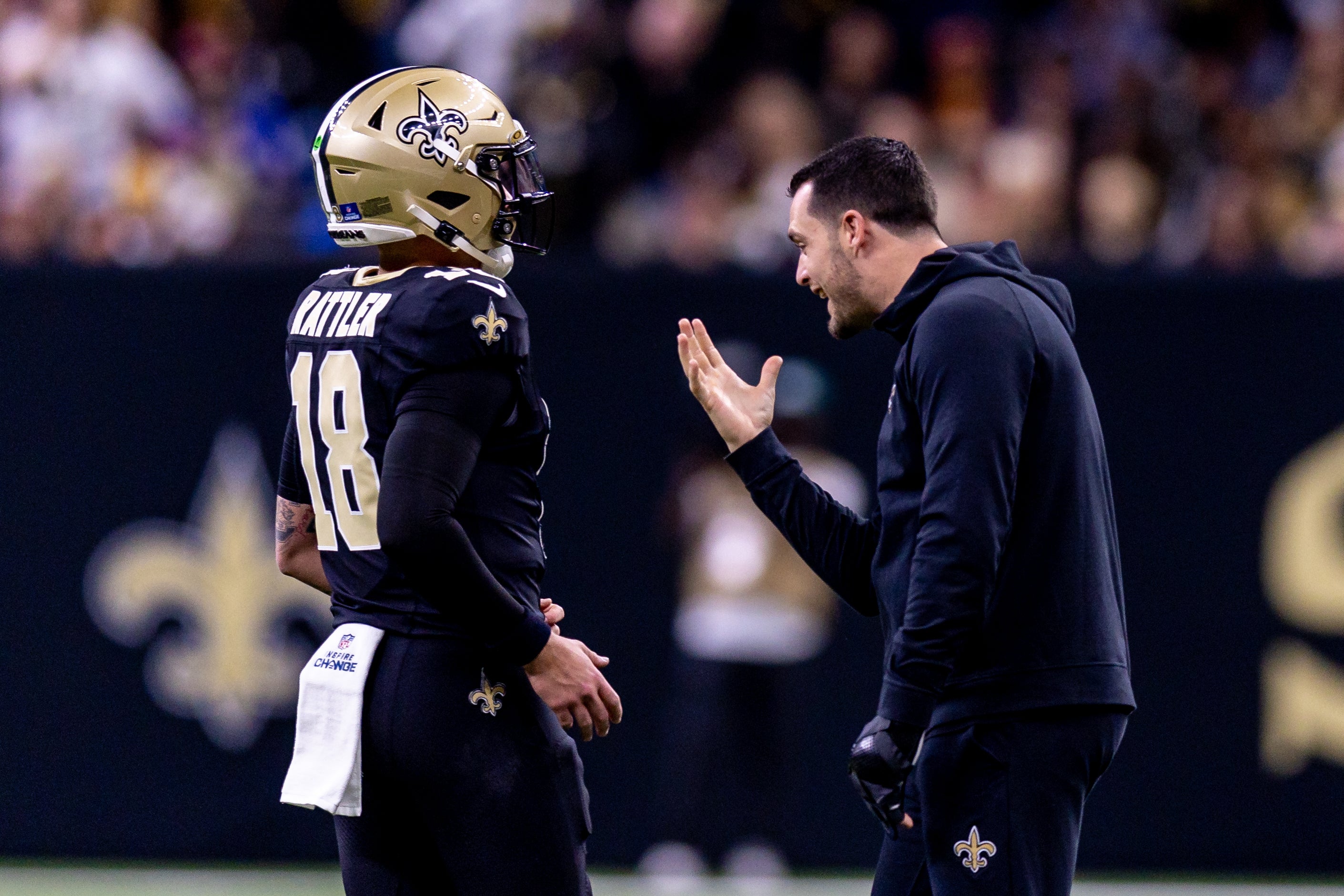 New Orleans Saints quarterback Derek Carr (4) jokes with quarterback Spencer Rattler (18) after a touchdown against the Washington Commanders during the second half at Caesars Superdome.