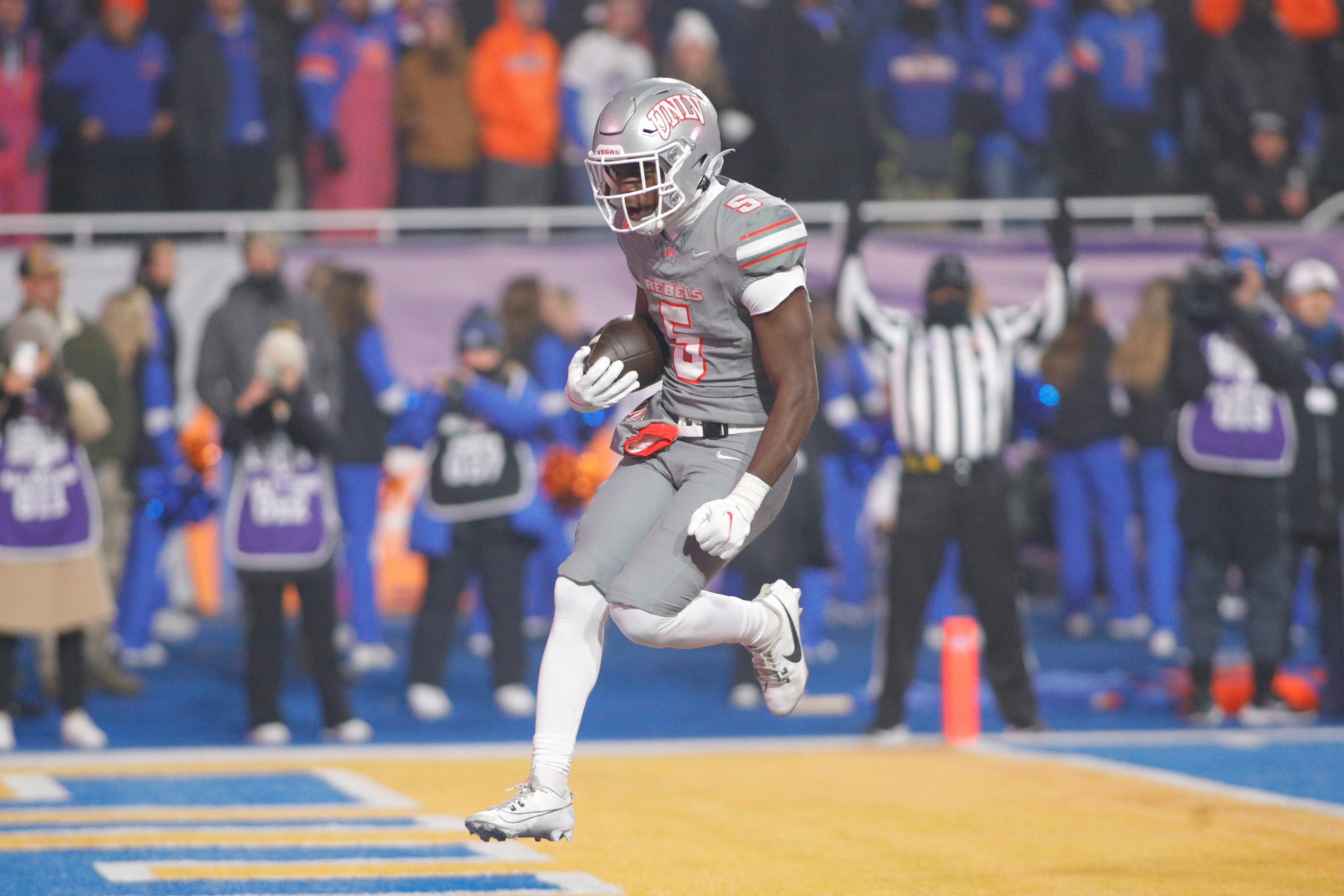 Dec 6, 2024; Boise, ID, USA; UNLV Rebels running back Greg Burrell (5) scores a touchdown during the second half against the Boise State Broncos at Albertsons Stadium. Boise State beats UNLV 21-7.