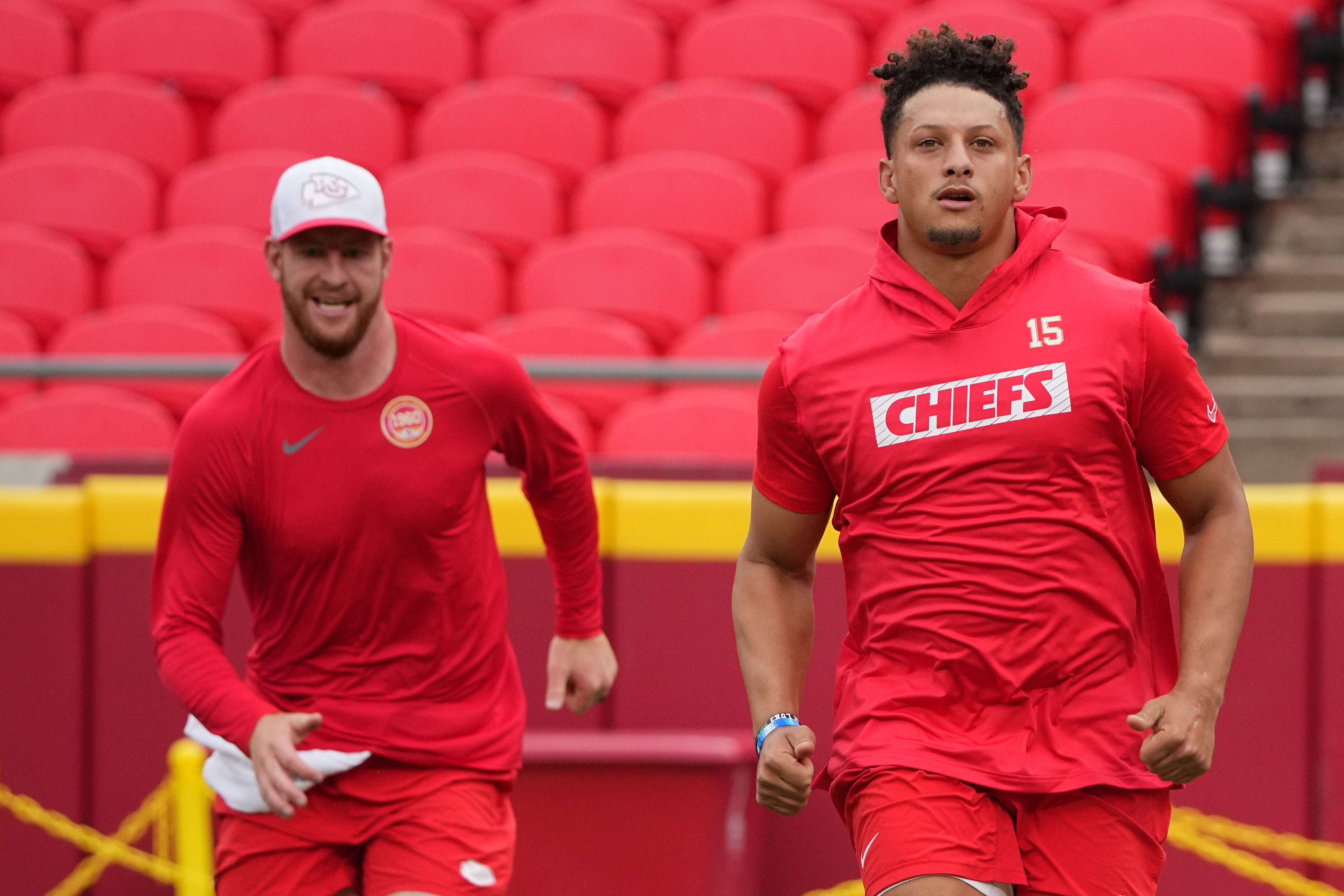 Aug 22, 2024; Kansas City, Missouri, USA; Kansas City Chiefs quarterback Patrick Mahomes (15) and quarterback Carson Wentz (11) warm up against the Chicago Bears prior to a game at GEHA Field at Arrowhead Stadium.