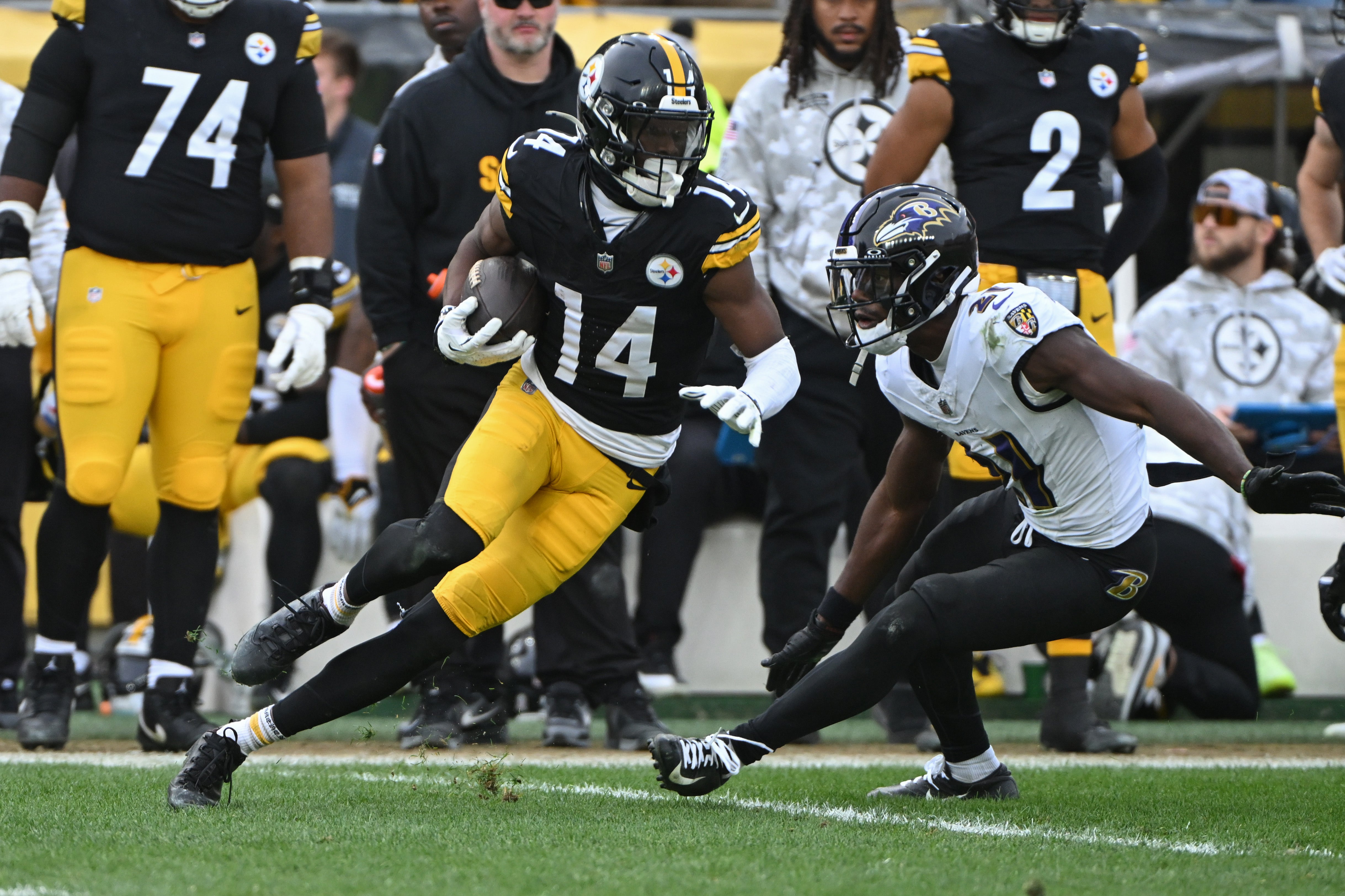 Nov 17, 2024; Pittsburgh, Pennsylvania, USA; Pittsburgh Steelers wide receiver George Pickens (14) looks to elude Baltimore Ravens cornerback Brandon Stephens (21) during the second quarter at Acrisure Stadium.