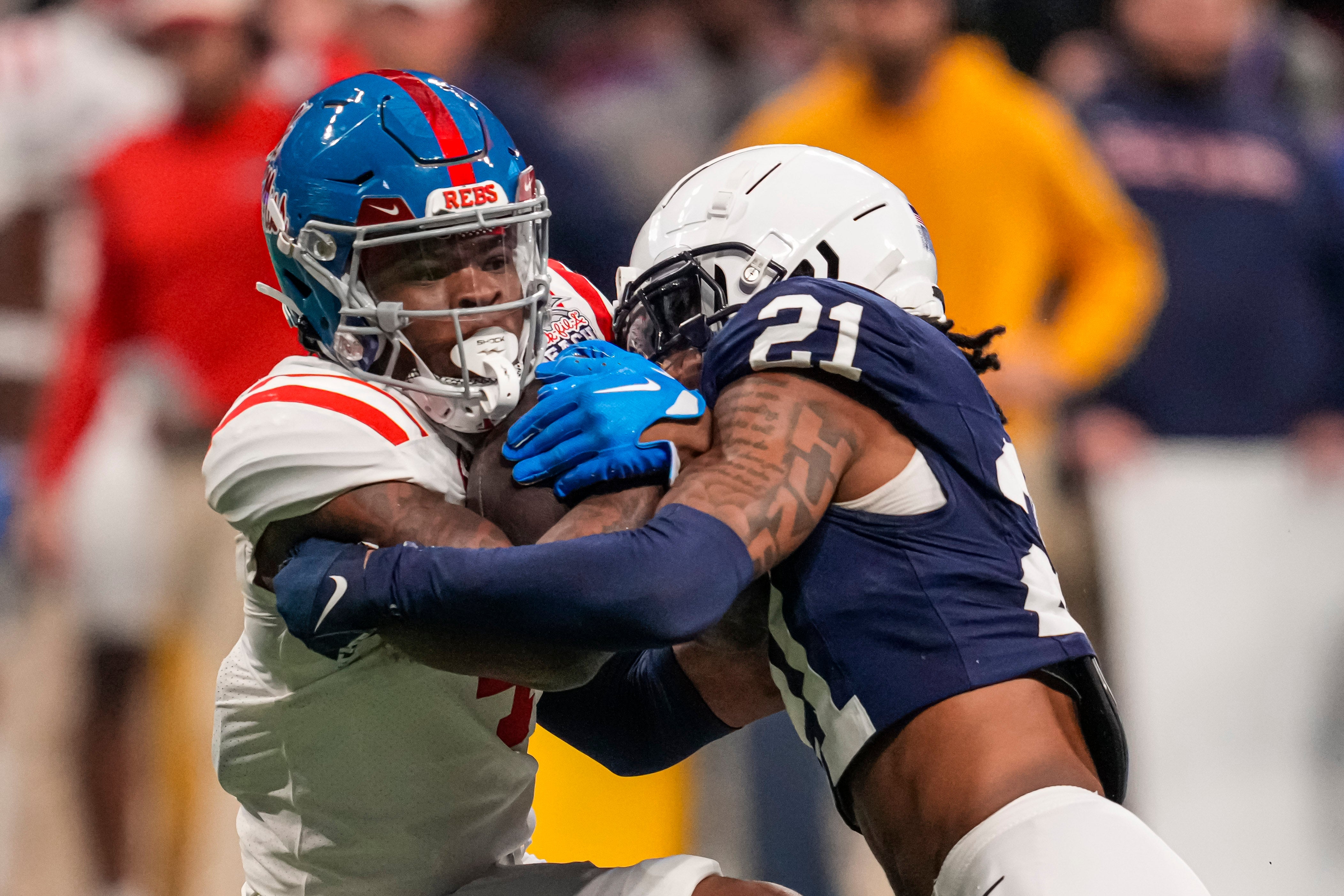 Mississippi Rebels running back Quinshon Judkins (4) is tackled by Penn State Nittany Lions safety Kevin Winston Jr. (21) during the second half at Mercedes-Benz Stadium.