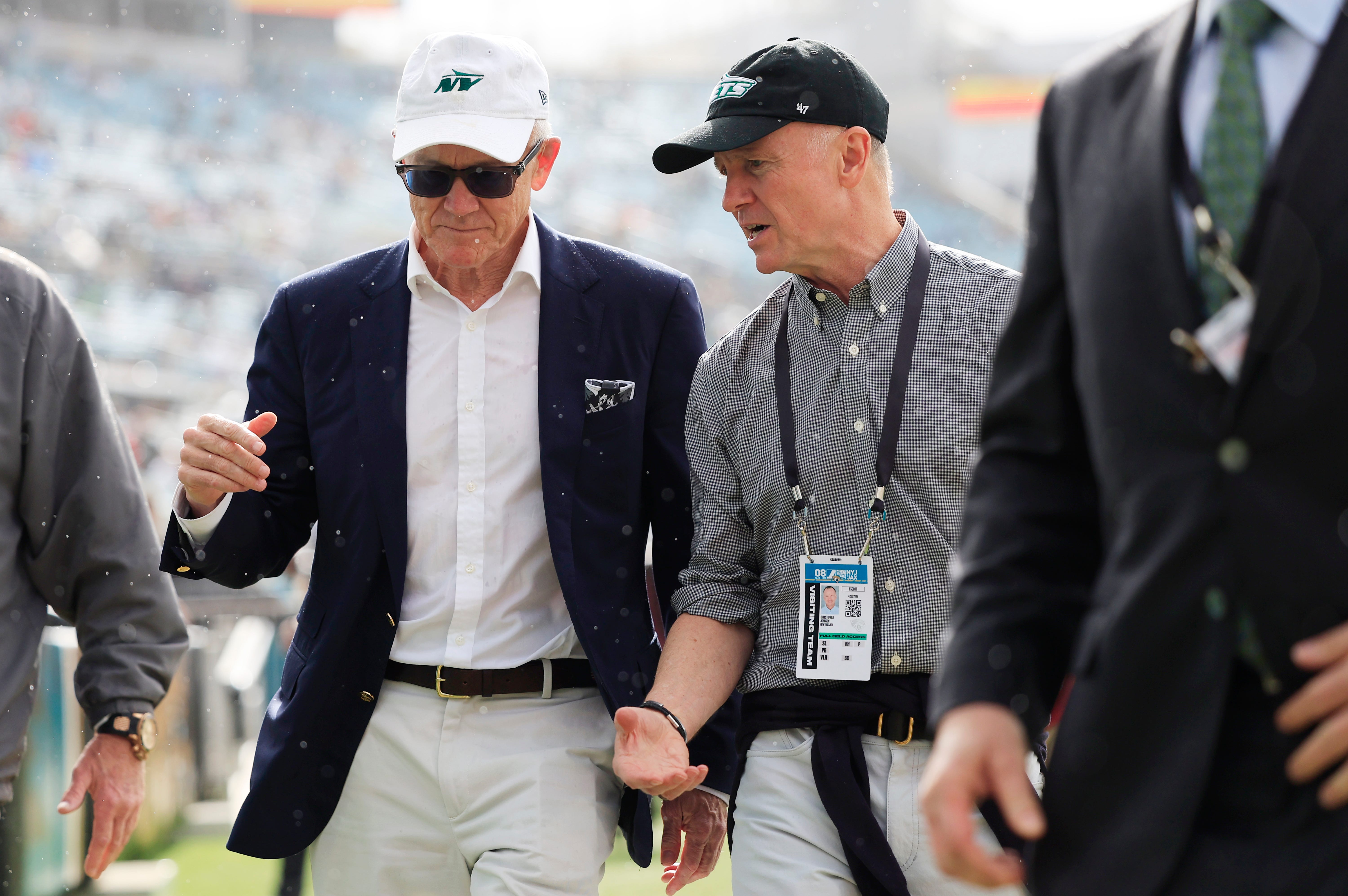 New York Jets co-owners Woody Johnson, center left, and brother Christopher Johnson, walk and talk before an NFL football matchup Sunday, Dec. 15, 2024 at EverBank Stadium in Jacksonville, Fla.