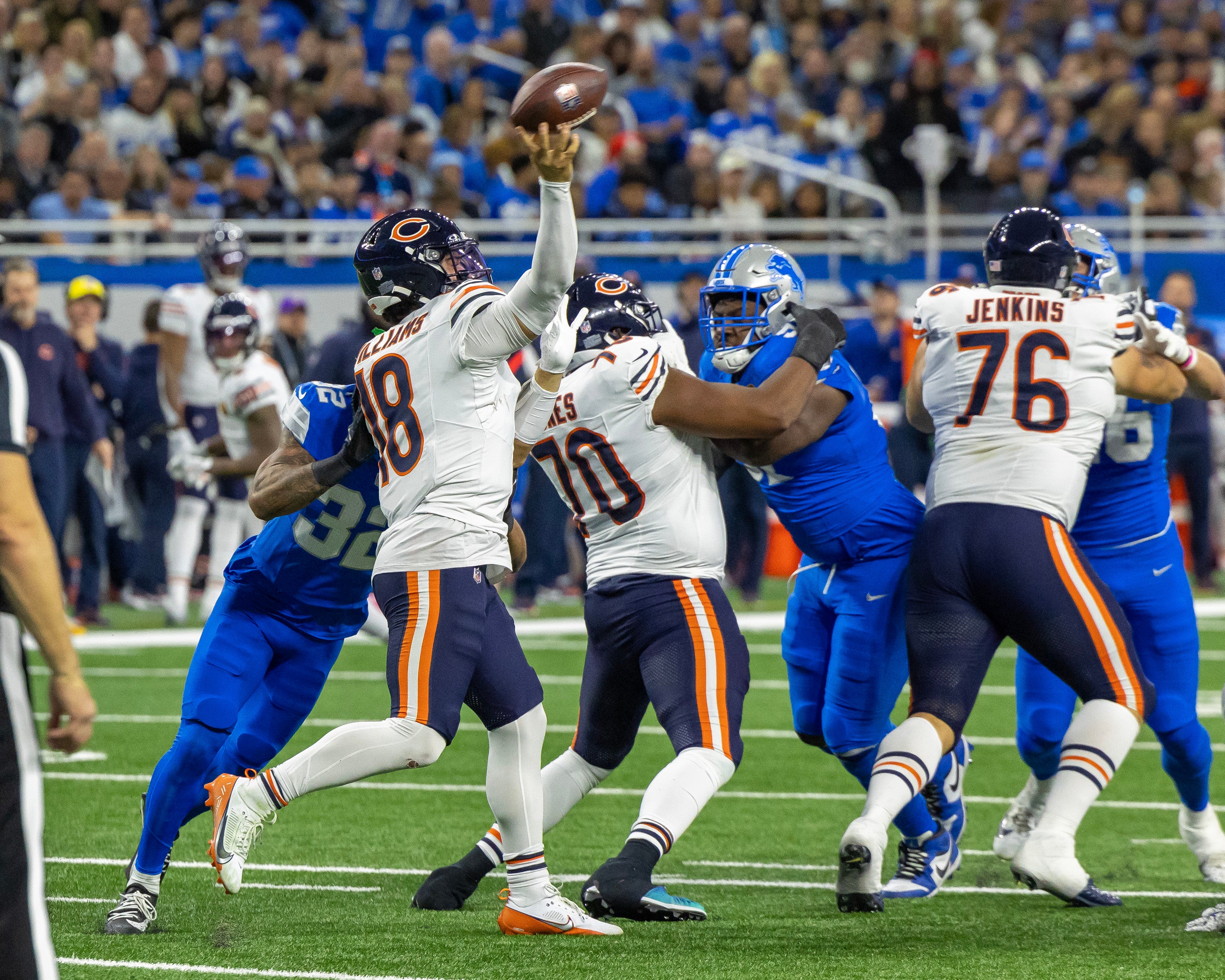 Nov 28, 2024; Detroit, Michigan, USA; Chicago Bears quarterback Caleb Williams (18) passes the ball as Detroit Lions safety Brian Branch (32) pressures from behind during the first half at Ford Field.