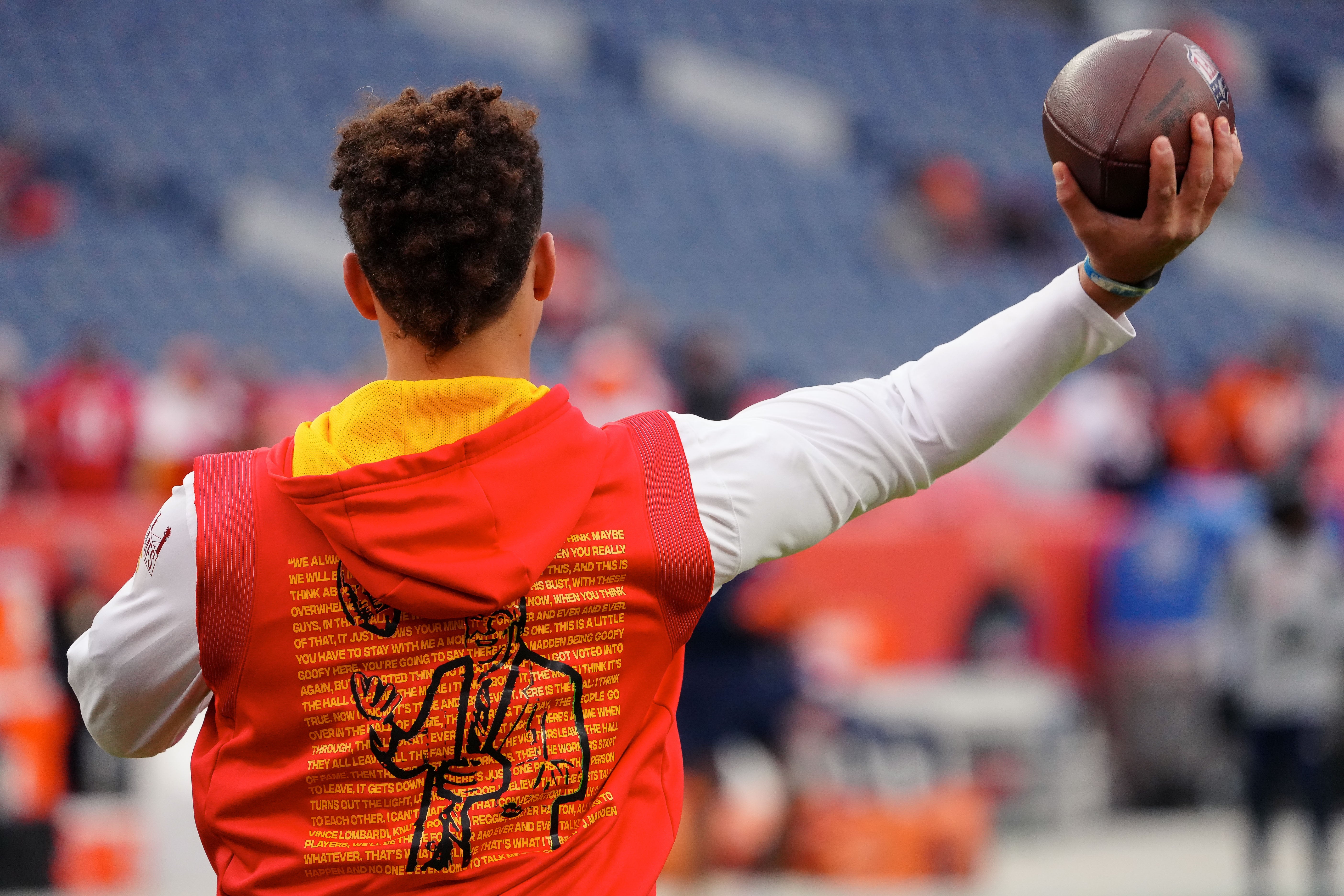 Jan 8, 2022; Denver, Colorado, USA; Kansas City Chiefs quarterback Patrick Mahomes (15) throws the ball during warmups in a hoodie depicting late football coach John Madden before the game against the Denver Broncos at Empower Field at Mile High.