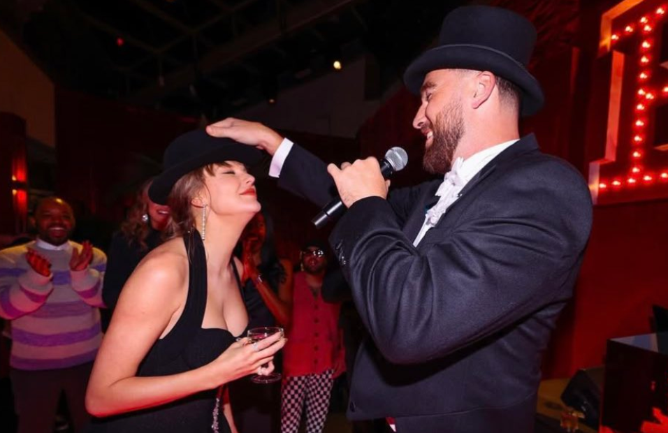 Travis Kelce gives Taylor Swift the 22 hat at her Eras Tour surprise birthday party.