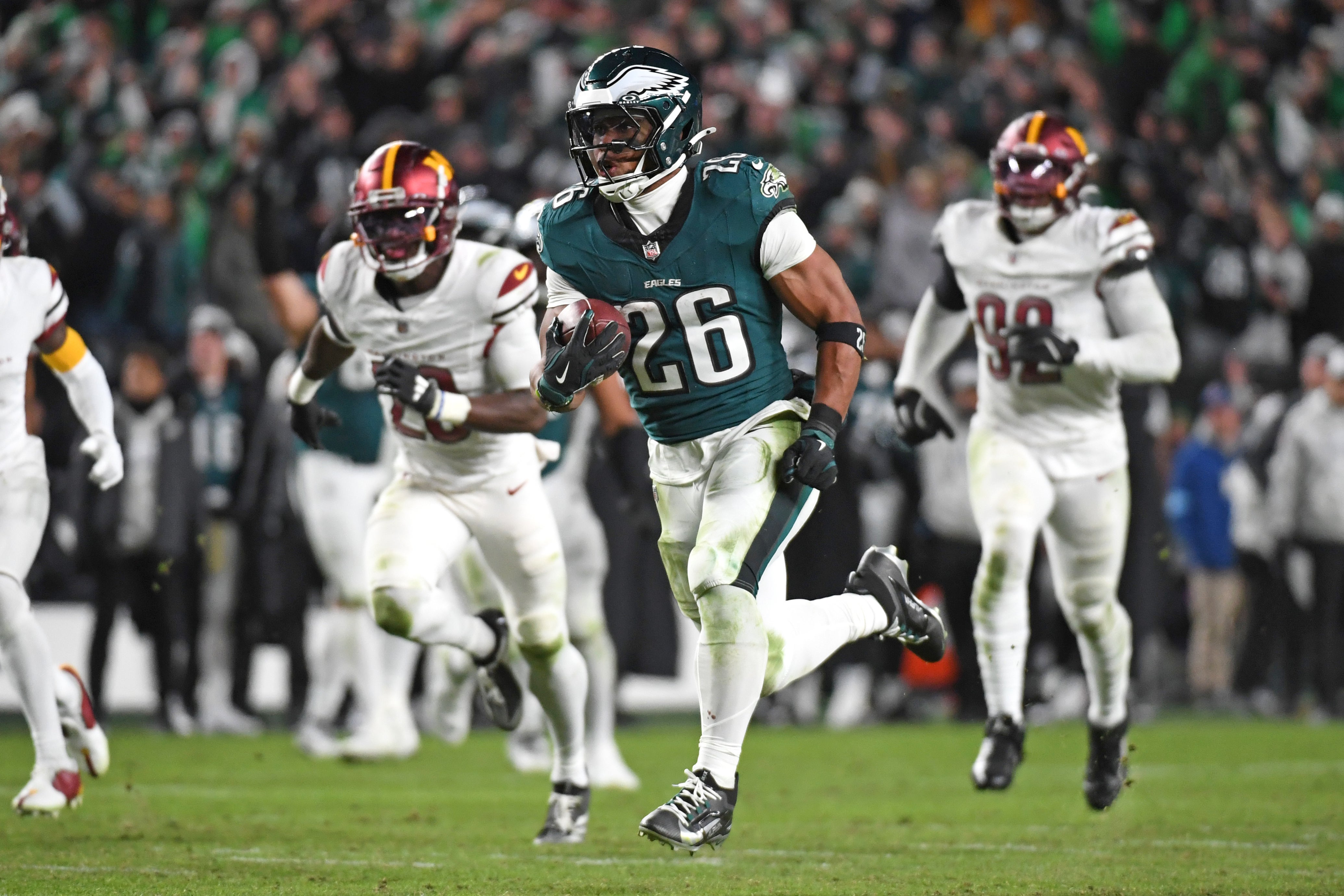 Philadelphia Eagles running back Saquon Barkley (26) runs past Washington Commanders defenders on way to a 39-yard touchdown during the fourth quarter against the Washington Commanders