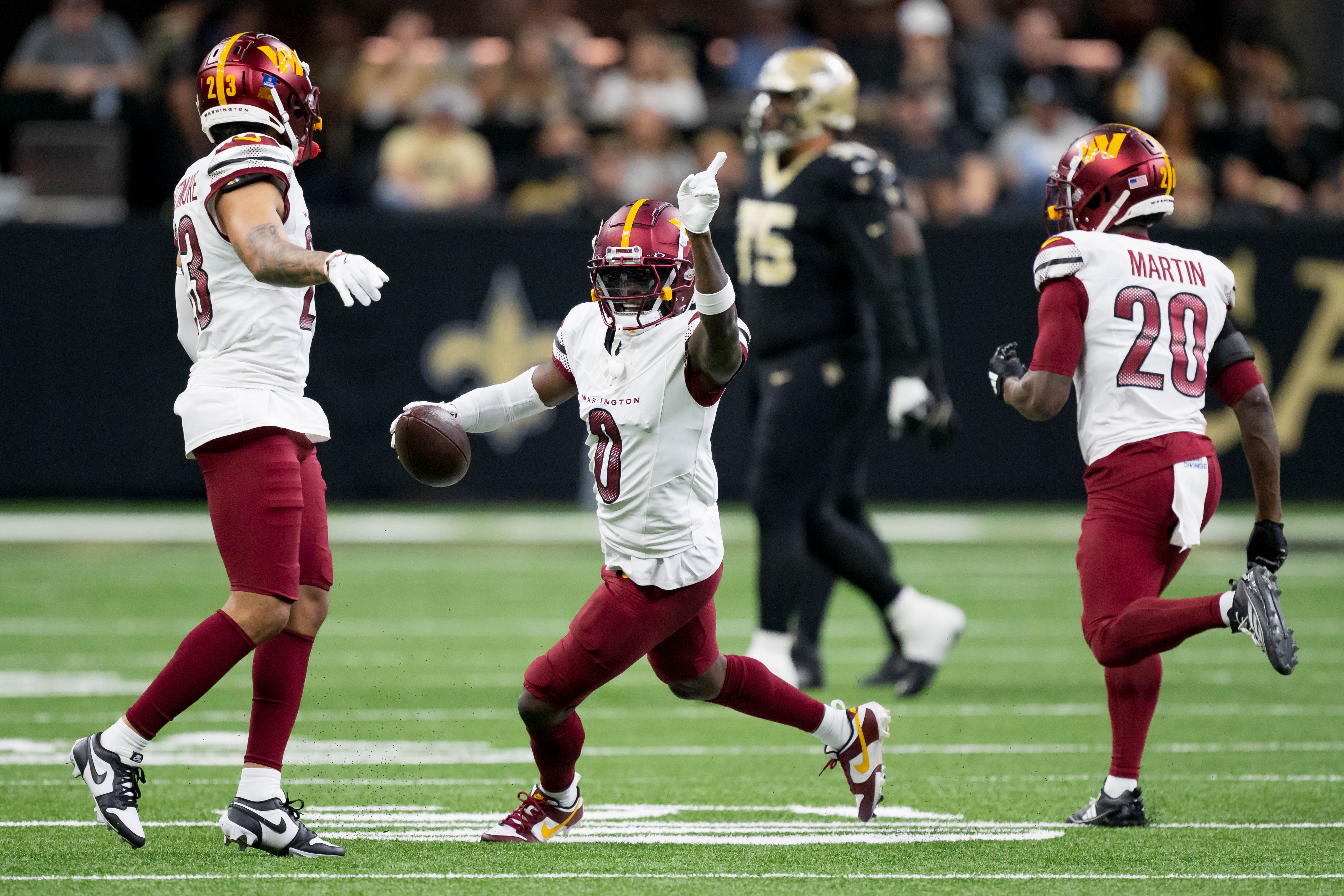 Dec 15, 2024; New Orleans, Louisiana, USA; Washington Commanders cornerback Mike Sainristil (0) celebrates an interception against New Orleans Saints running back Alvin Kamara (41) during the first half at Caesars Superdome.