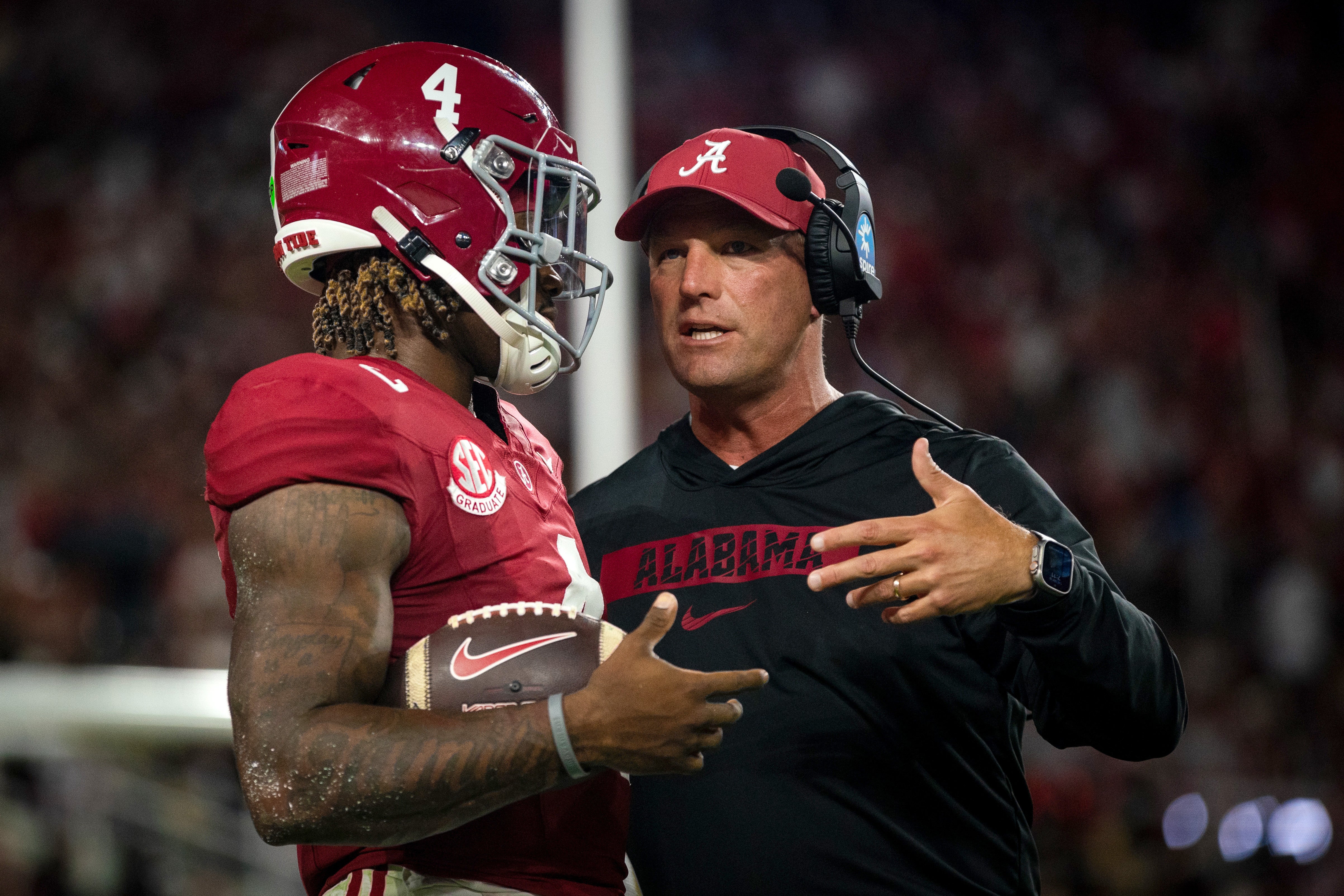 Sep 28, 2024; Tuscaloosa, Alabama, USA; Alabama Crimson Tide quarterback Jalen Milroe (4) and head coach Kalen DeBoer talk during a timeout in the first quarter against the Georgia Bulldogs at Bryant-Denny Stadium.
