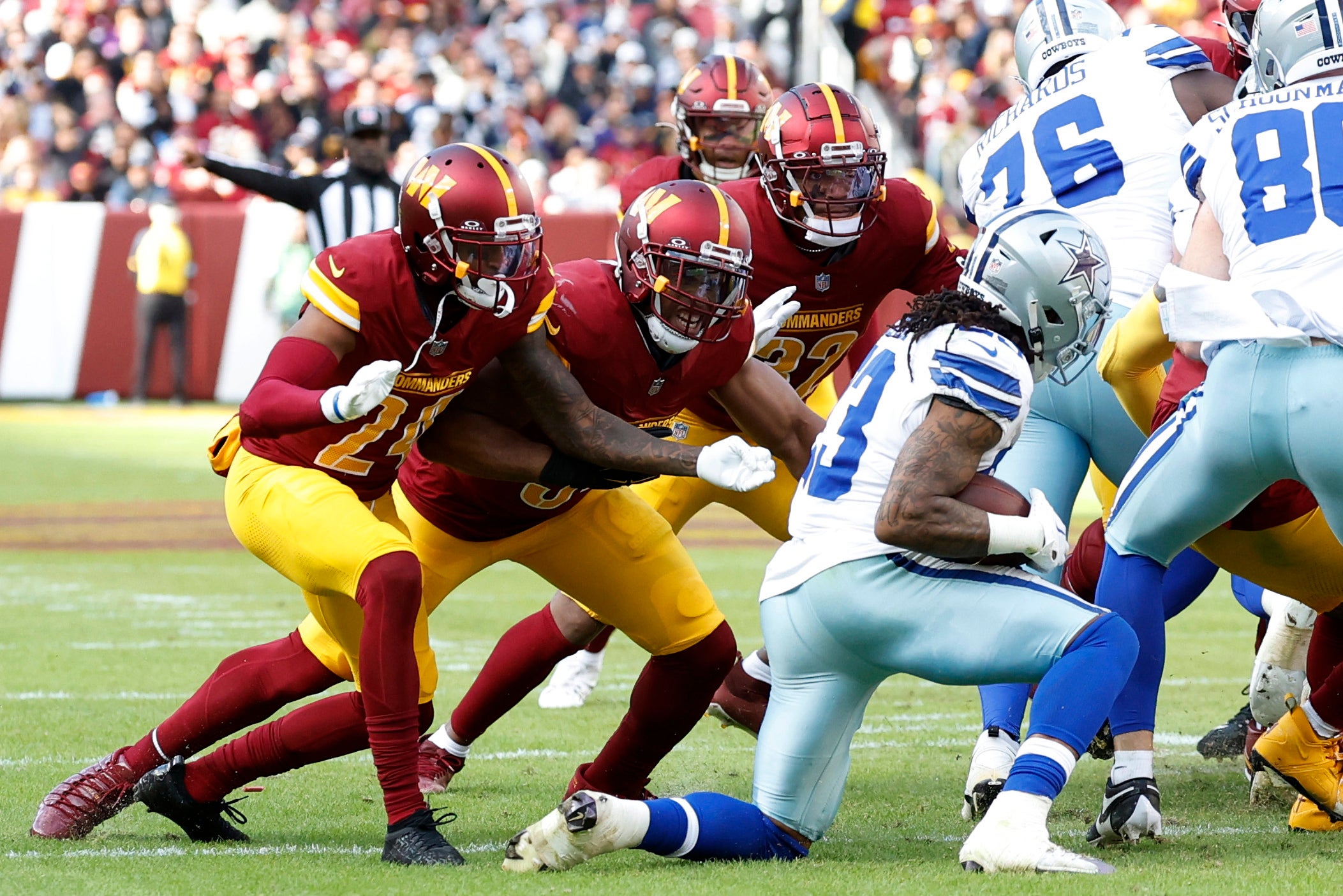 Washington Commanders cornerback Michael Davis (24), Commanders linebacker Bobby Wagner (54), and Commanders linebacker Mykal Walker (32) prepare to tackle Dallas Cowboys running back Rico Dowdle (23) at Northwest Stadium.