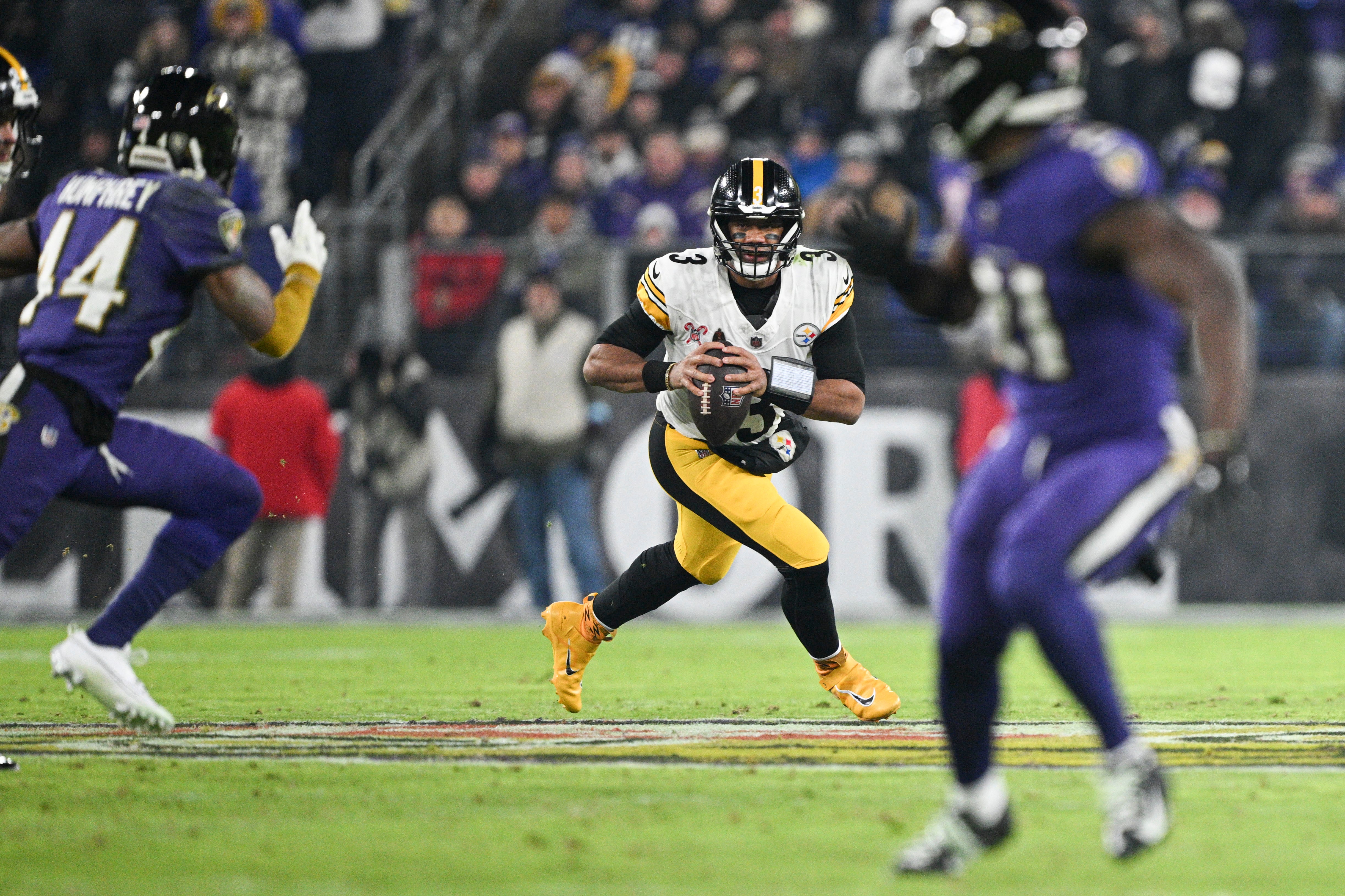 Dec 21, 2024; Baltimore, Maryland, USA; Pittsburgh Steelers quarterback Russell Wilson (3) rolls pout top pass durn the first half against the Baltimore Ravens at M&T Bank Stadium.