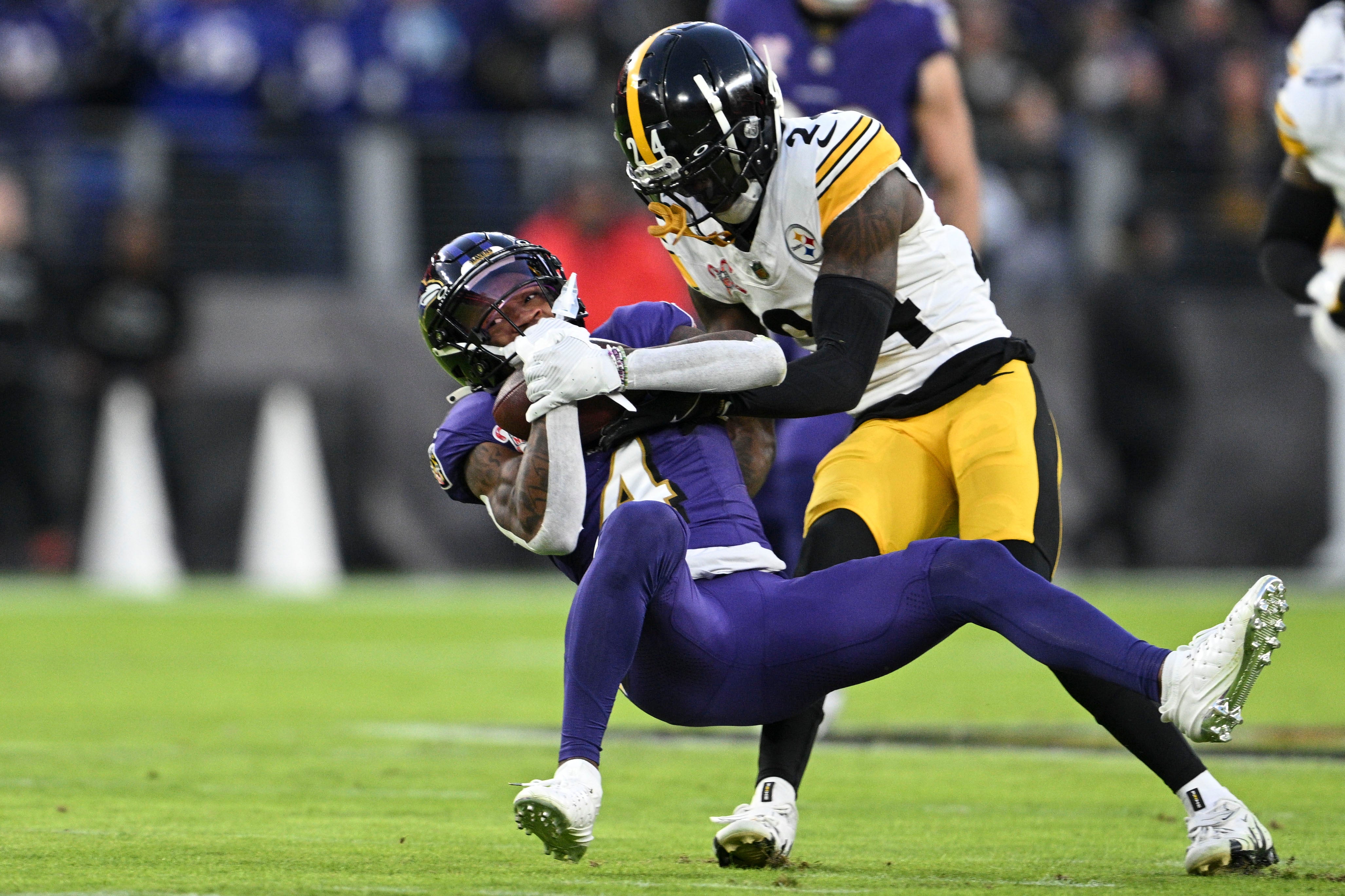 Dec 21, 2024; Baltimore, Maryland, USA; Pittsburgh Steelers cornerback Joey Porter Jr. (24) tackles Baltimore Ravens wide receiver Zay Flowers (4) during the first half at M&T Bank Stadium.