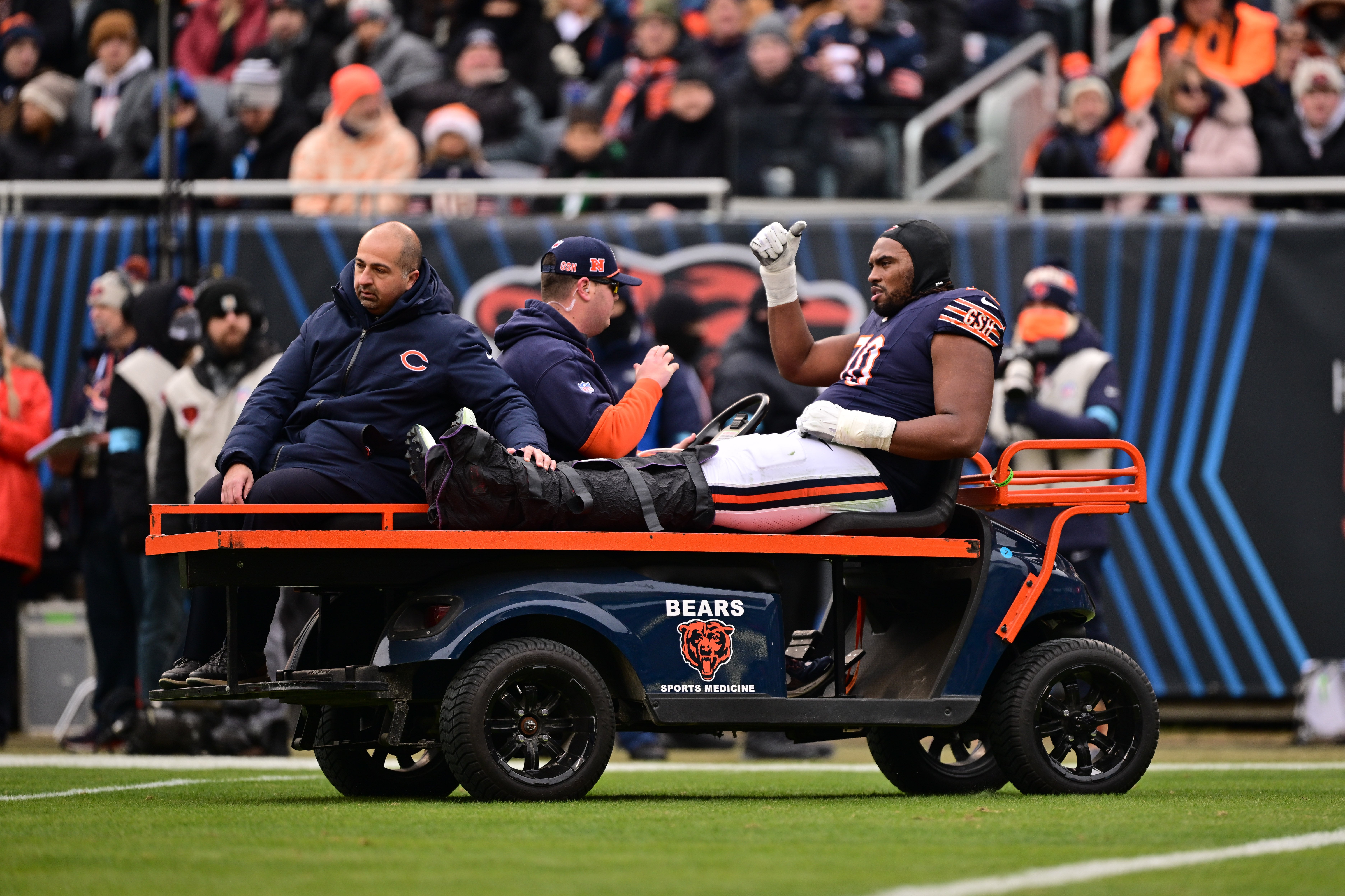 Dec 22, 2024; Chicago, Illinois, USA; Chicago Bears offensive tackle Braxton Jones (70) is carted off the field against the Detroit Lions during the second quarter at Soldier Field.
