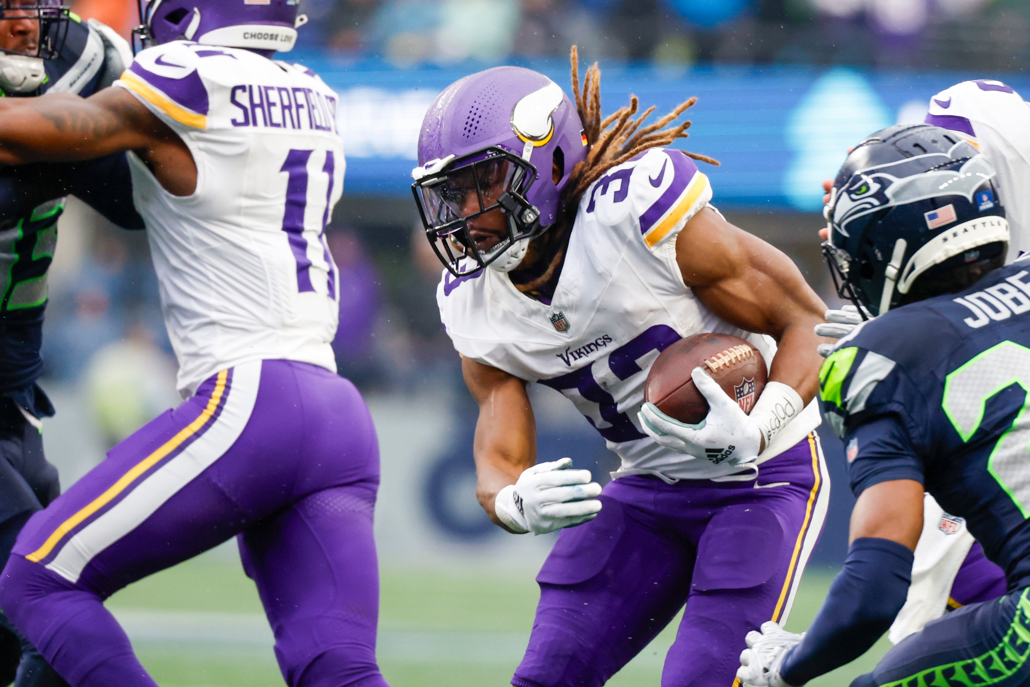 Dec 22, 2024; Seattle, Washington, USA; Minnesota Vikings running back Aaron Jones (33) rushes against the Seattle Seahawks during the first quarter at Lumen Field.