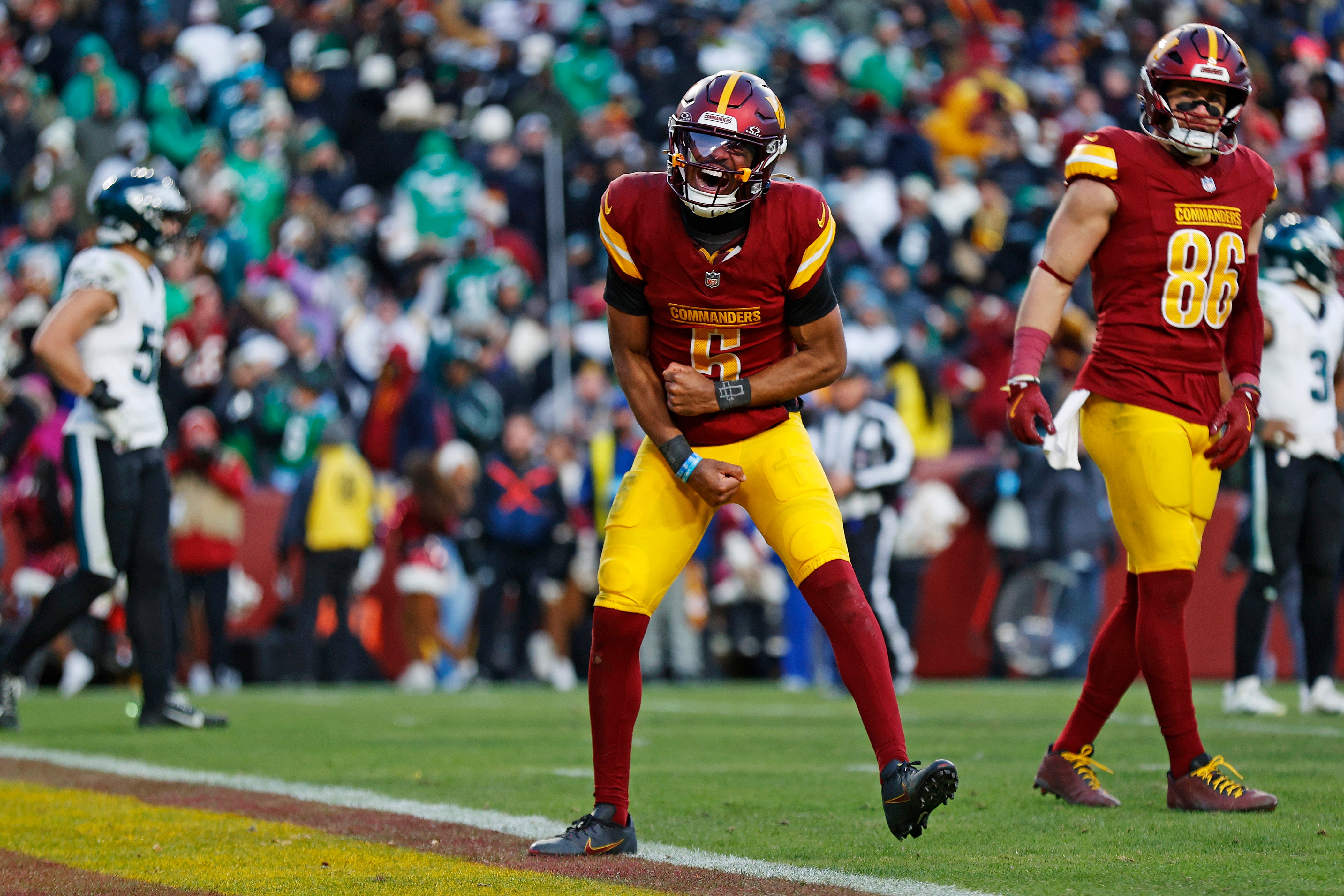 Dec 22, 2024; Landover, Maryland, USA; Washington Commanders quarterback Jayden Daniels (5) celebrates after throwing the game winning touchdown during the fourth quarter against the Philadelphia Eagles at Northwest Stadium.