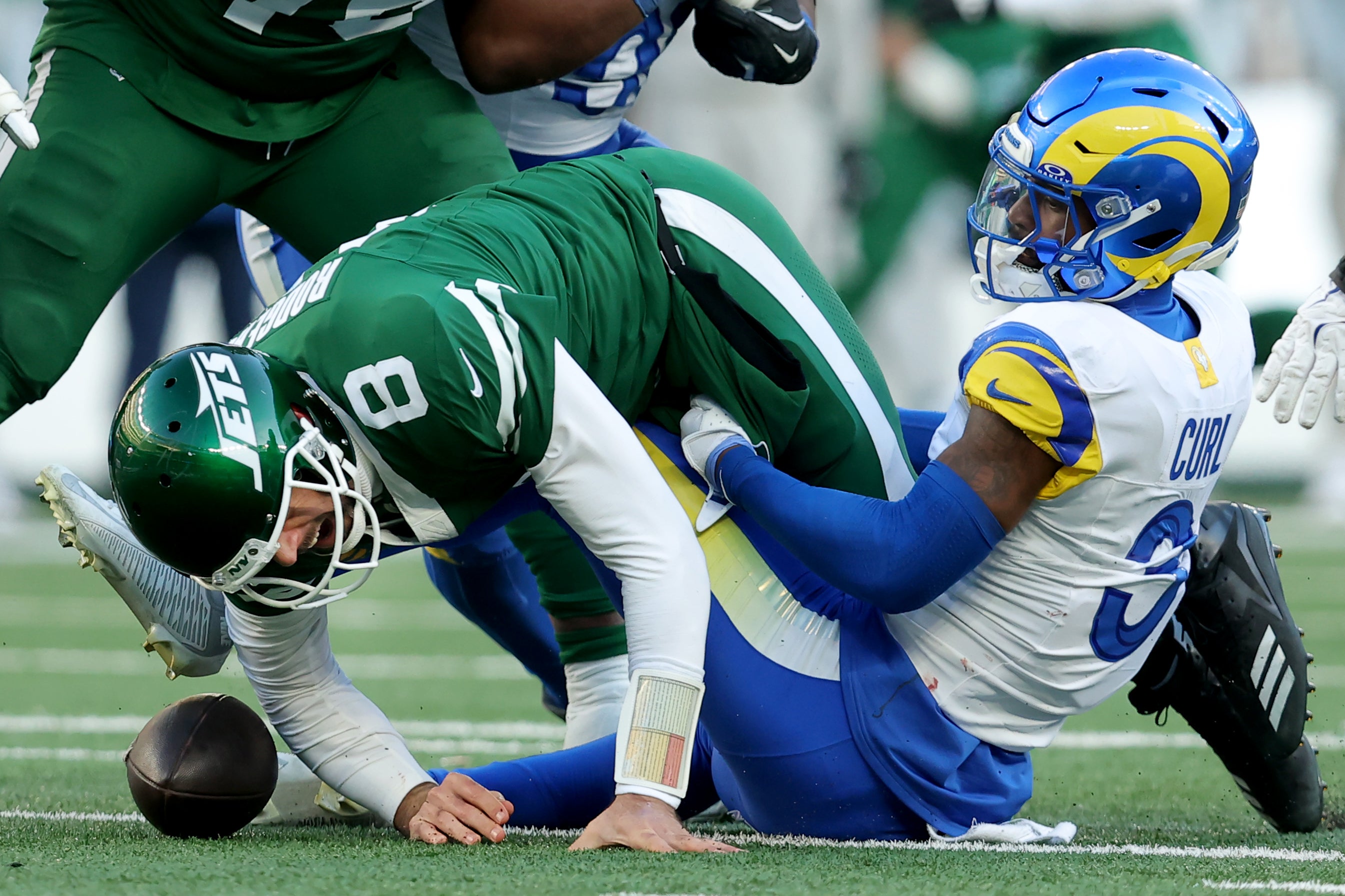 New York Jets quarterback Aaron Rodgers (8) fumbles the ball after a hit by Los Angeles Rams safety Kamren Curl (3) during the fourth quarter at MetLife Stadium.