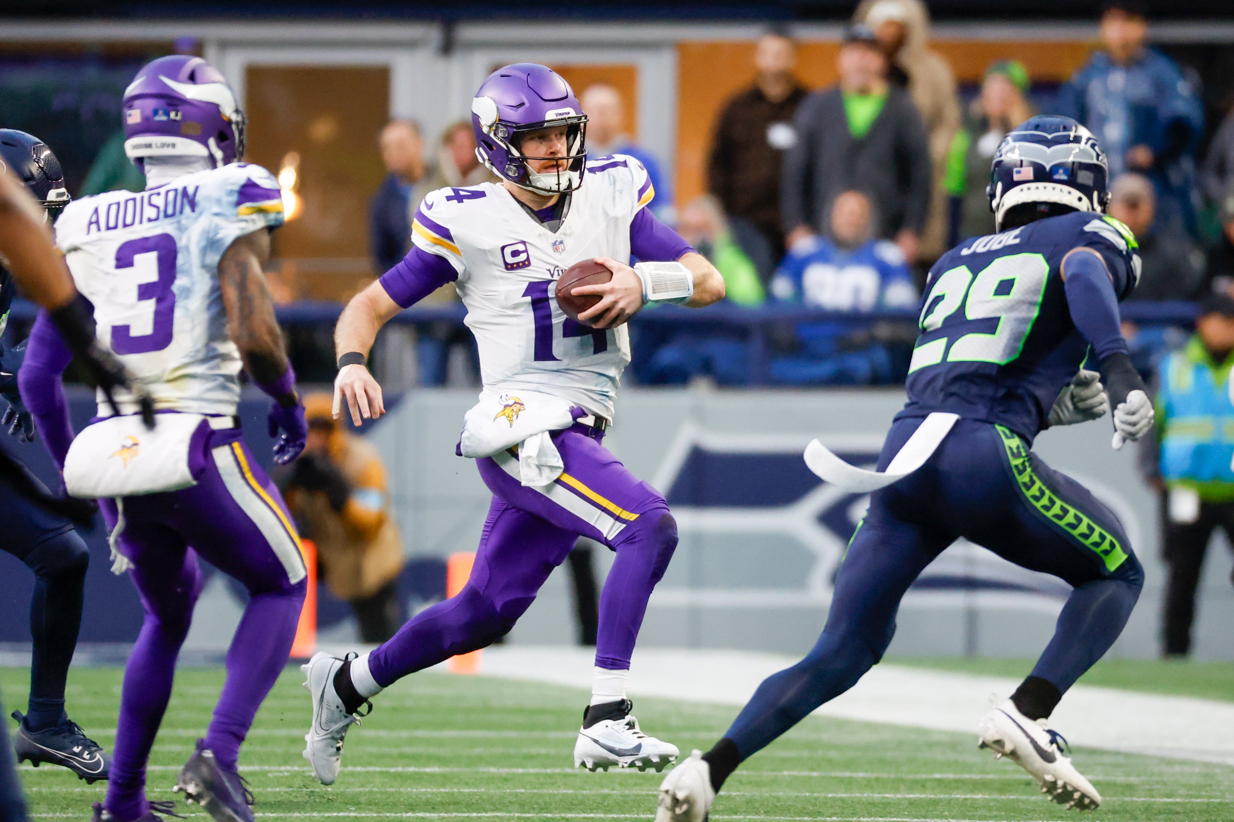 Dec 22, 2024; Seattle, Washington, USA; Minnesota Vikings quarterback Sam Darnold (14) rushes against the Seattle Seahawks during the fourth quarter at Lumen Field.