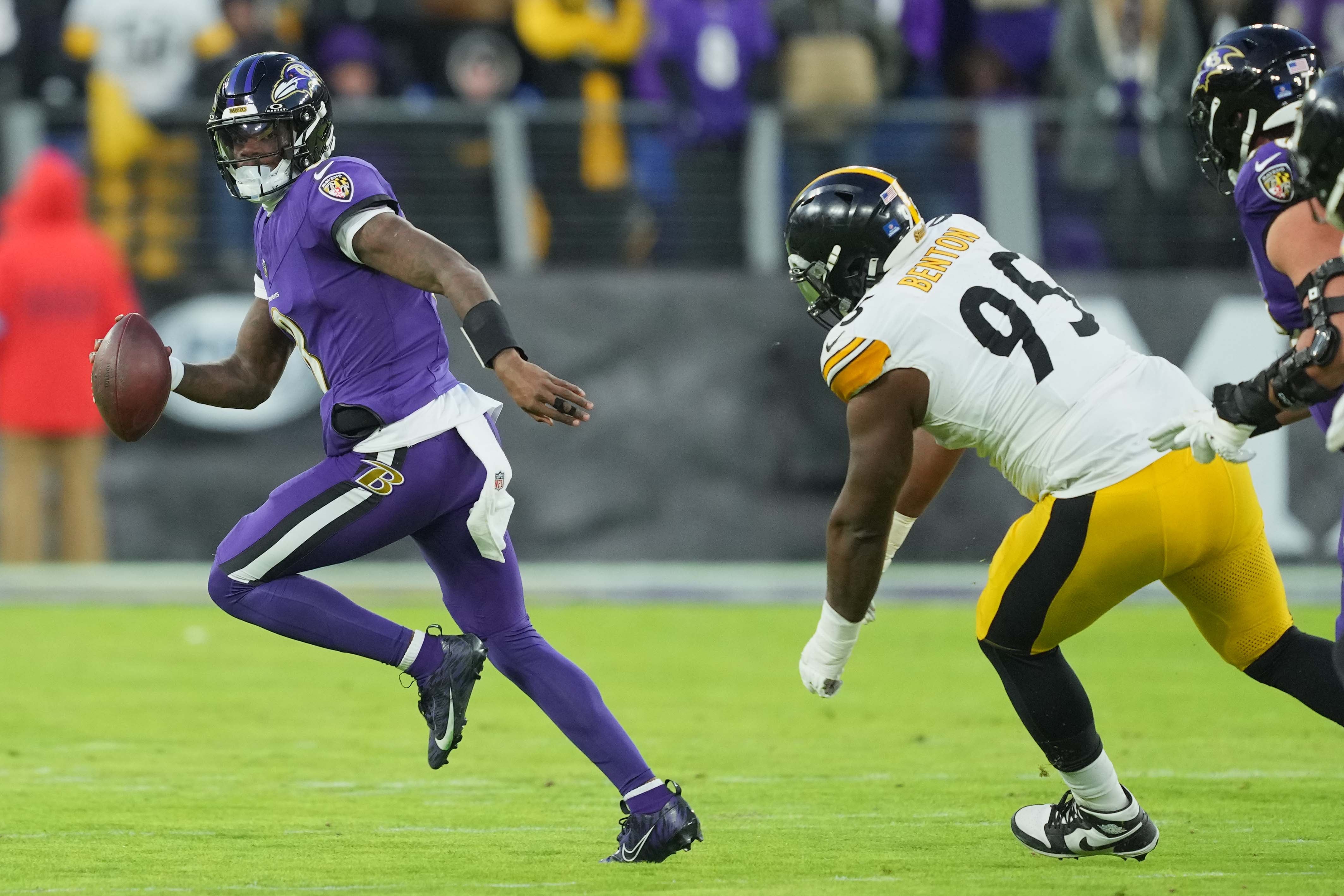 Baltimore Ravens quarterback Lamar Jackson (8) scrambles during the first quarter pressured by Pittsburgh Steelers tackle Keeanu Benton (95) at M&T Bank Stadium.