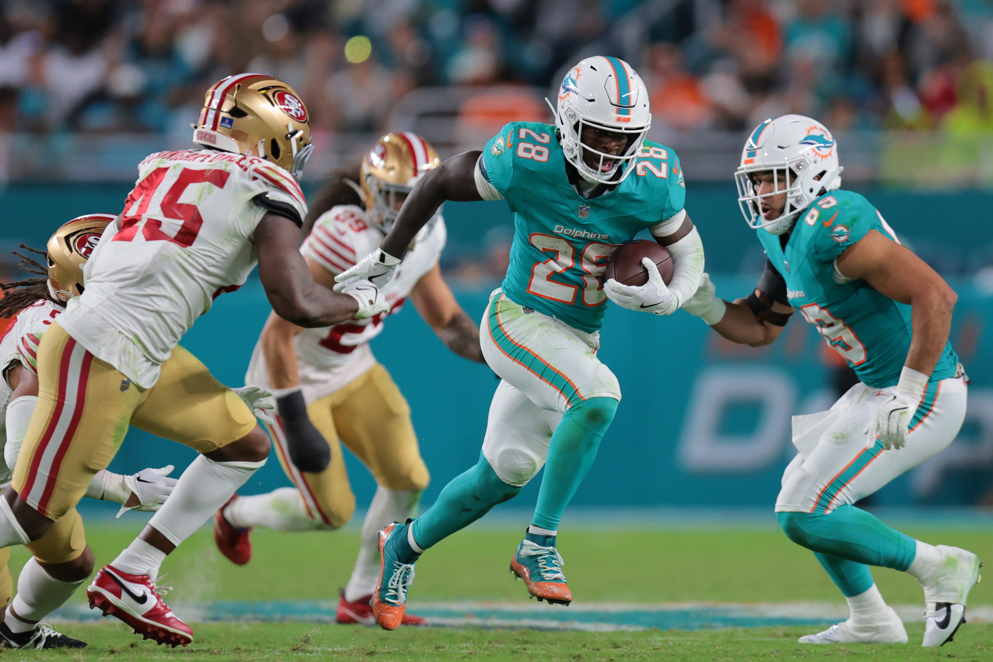 Dec 22, 2024; Miami Gardens, Florida, USA; Miami Dolphins running back De'Von Achane (28) runs with the football against the San Francisco 49ers during the fourth quarter at Hard Rock Stadium.